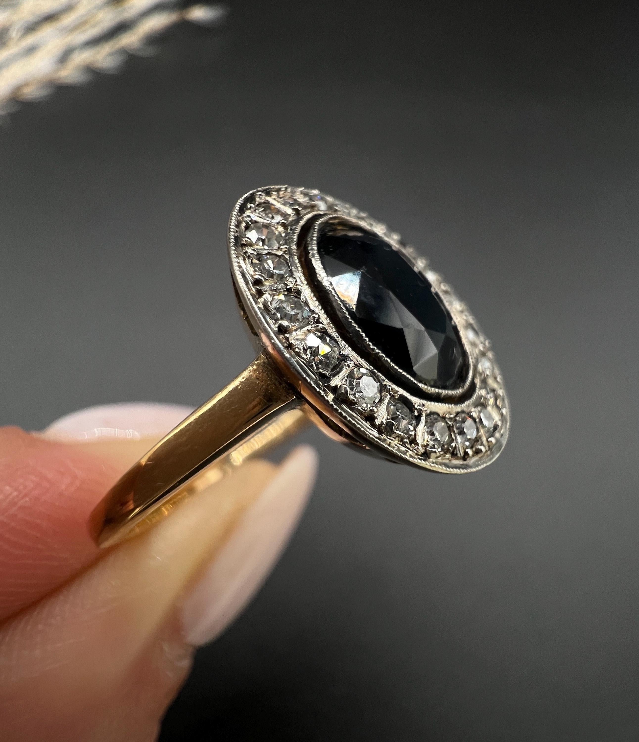 Antique Halo Ring

18ct Gold Stamped

Circa 1920s

Step into the elegance of the 1920s with this stunning antique ring, expertly crafted from 18ct yellow gold. At its centre, a mesmerising oval faceted natural sapphire catches the light, radiating