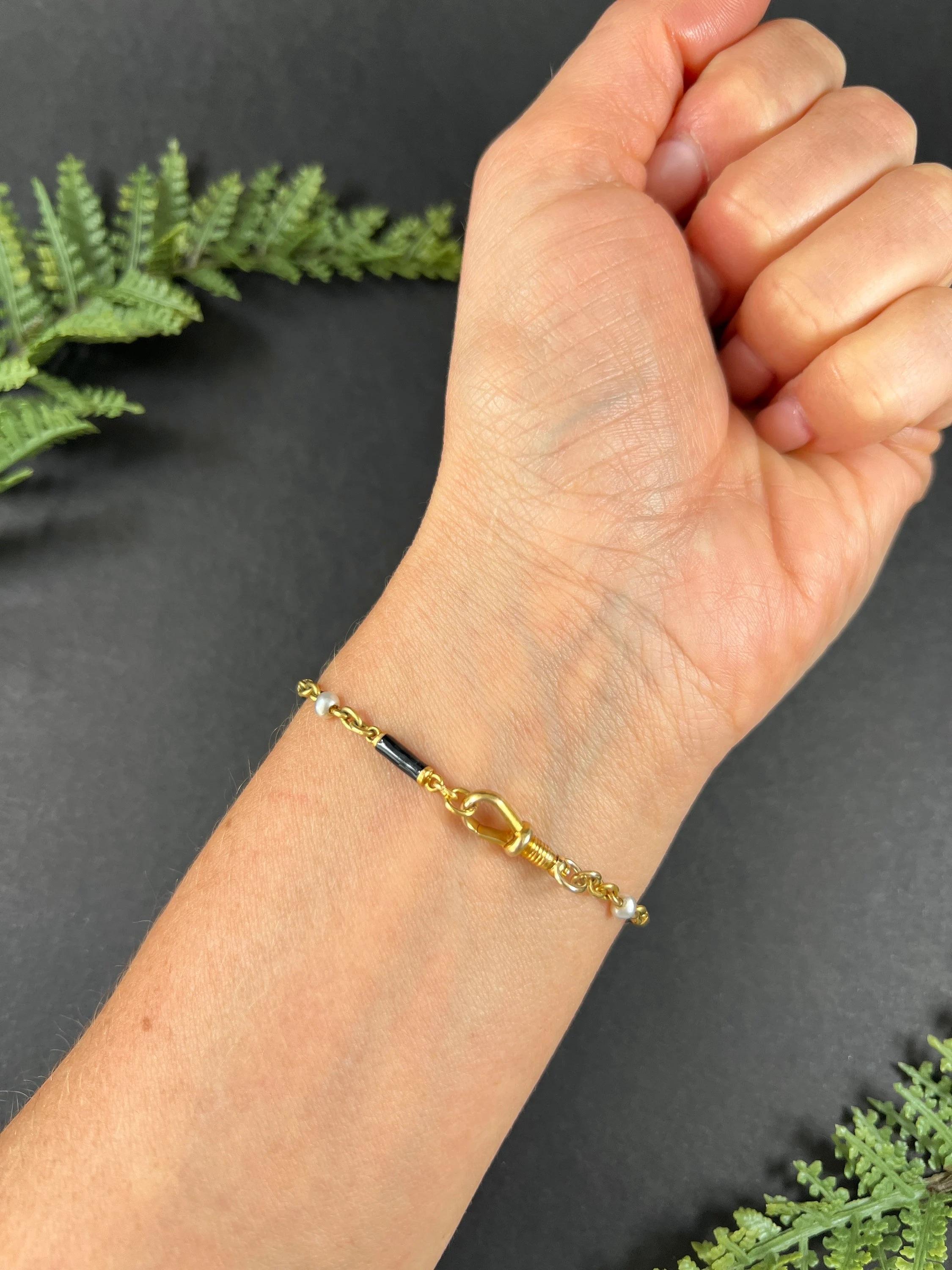 Antique Enamel & Pearl Bracelet

18ct Gold Tested

Circa 1880

Introducing a stunning Handmade 18ct yellow gold bracelet. This beautiful piece showcases alternating black enamel and natural seed pearl links, intricately connected by gold trace