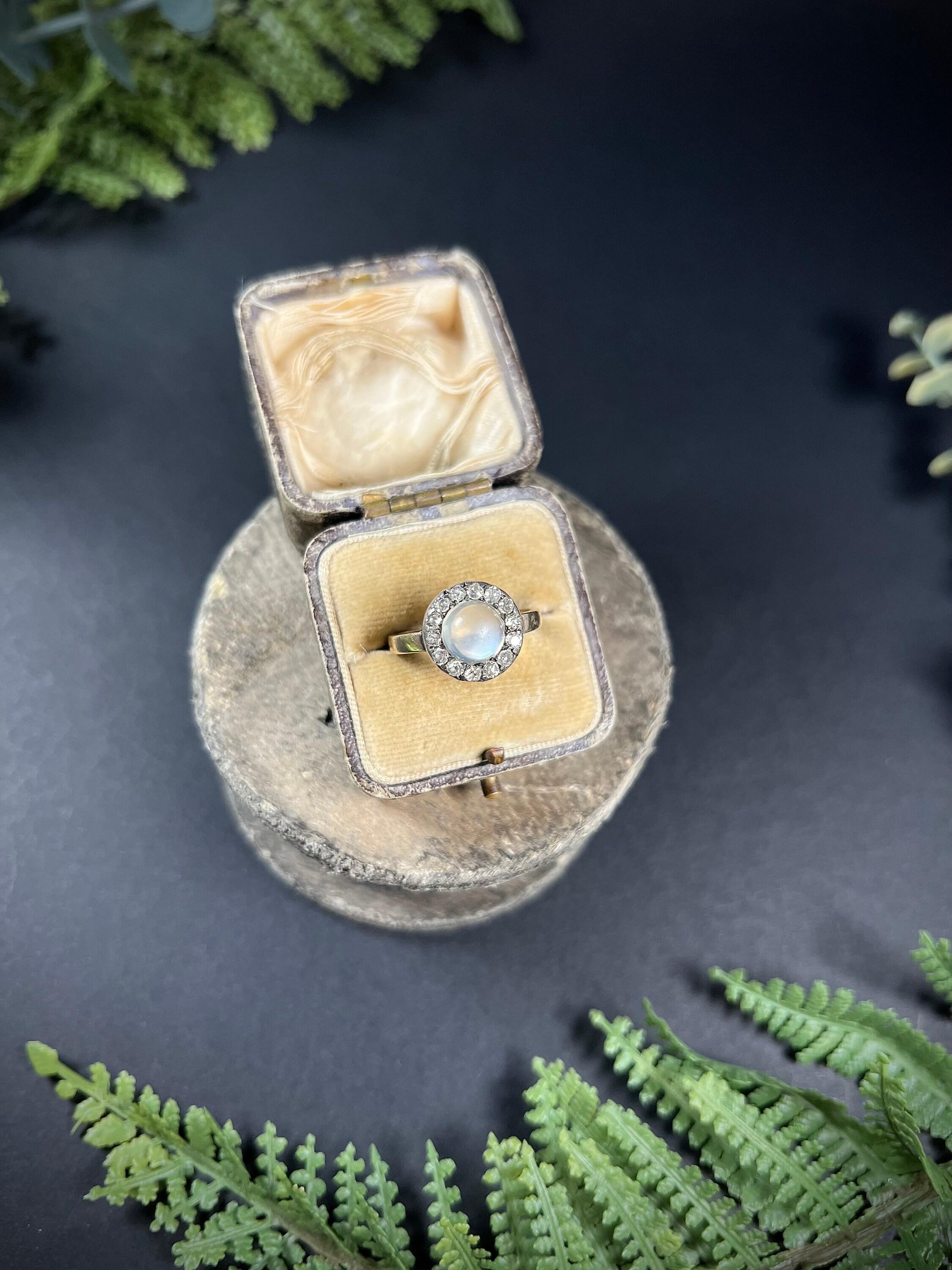Antique Moonstone Ring

18ct Gold Stamped 

Circa 1870’s 

Beautiful, Victorian cluster ring. Set with a fabulous moonstone centre & surrounded by a halo of natural diamonds. Features a lovely gold, pie crust setting & mounted on a 2.4mm, 18ct
