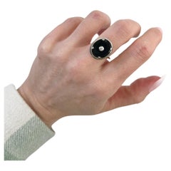 Ancienne bague de forme ovale en onyx 18 carats sertie d'un halo de diamants et d'une cage de jonc en or rose