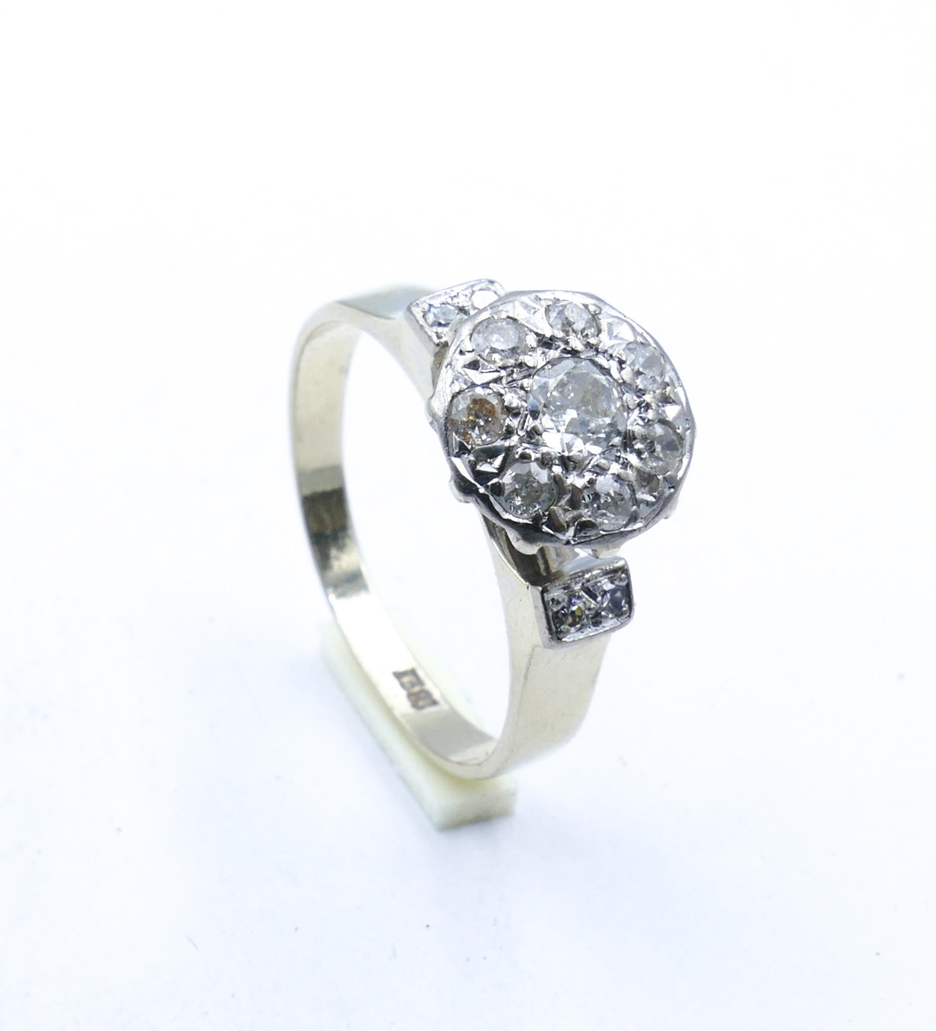 The central feature of this very pretty old Ring is a 0.20 carat round old cut 'G' grade Diamond.
Surrounding this are 7 round old cut Diamonds with an extra 4 single cut Diamonds set into the shoulders of the Ring which then settles into quite a