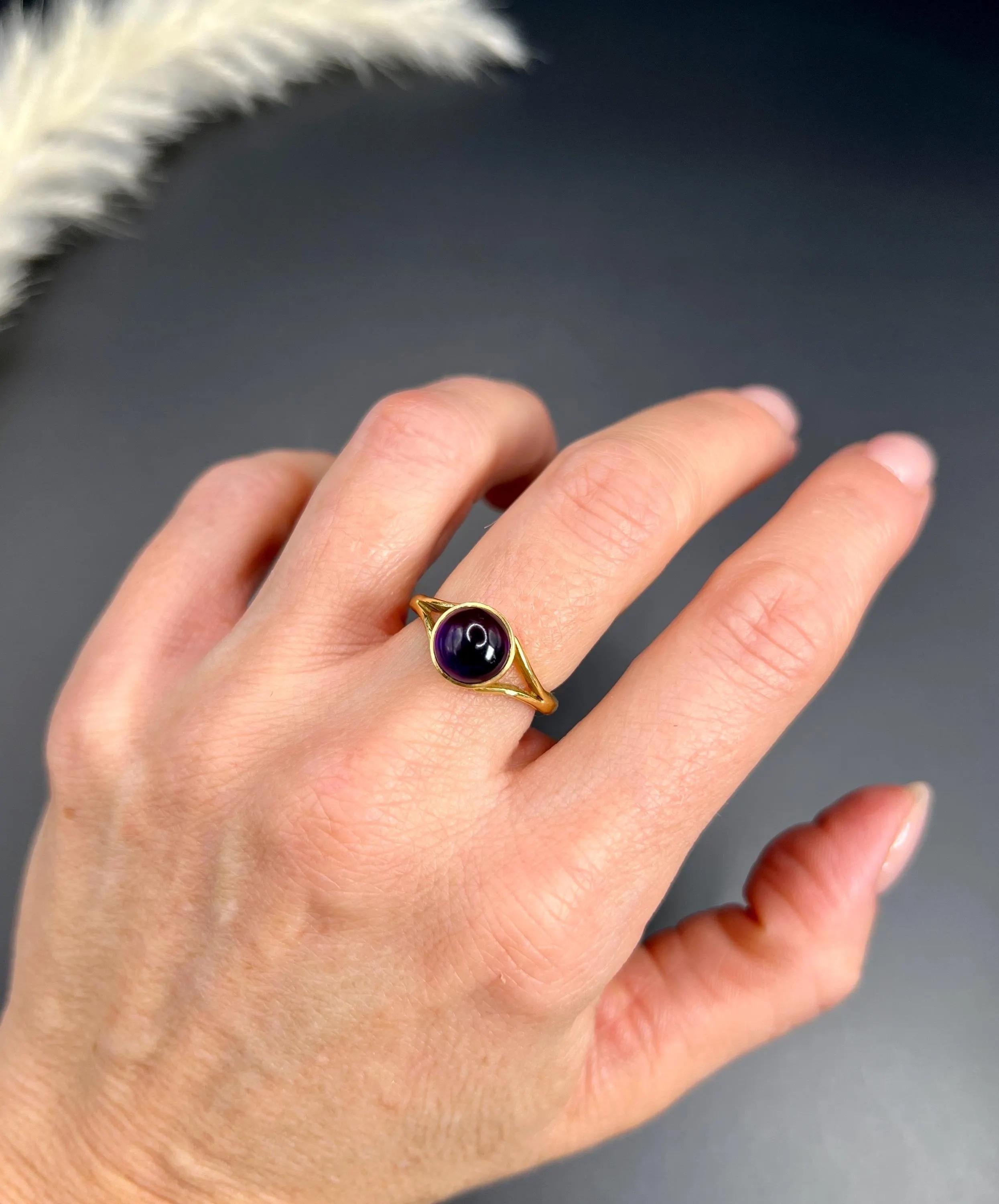 Antique Amethyst Ring 

18ct Gold Tested

Circa 1920s

Experience the elegance of the 1920s with this exquisite 18ct gold cabochon amethyst ring. Set against a backdrop of split yellow gold shoulders, the beautifully mounted amethyst takes centre