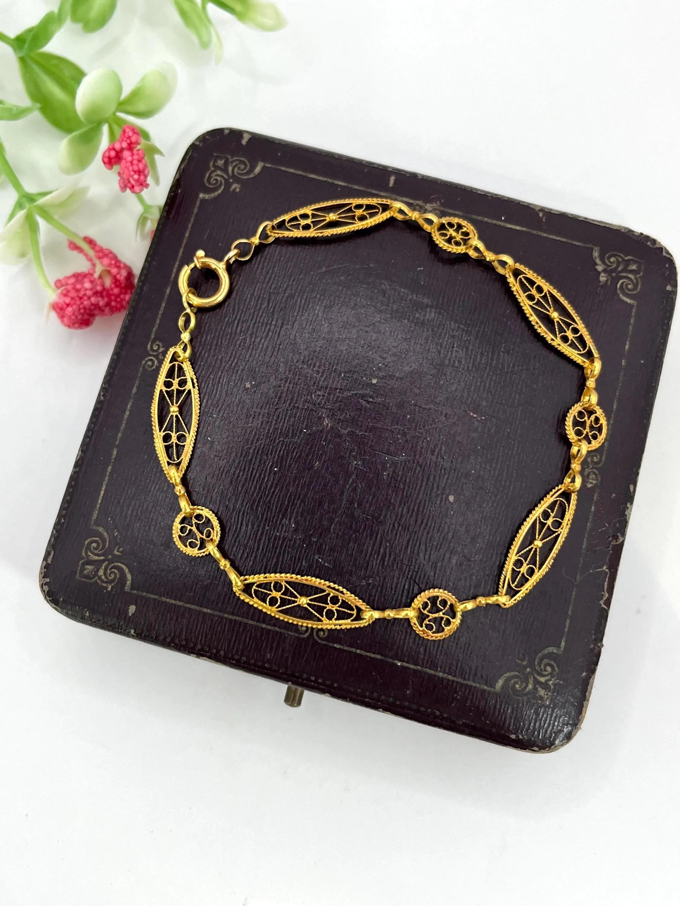 Bracelet en or antique 

Or 18 carats

Circa 1920s

Un bracelet décoratif finement travaillé en or jaune 18ct, composé d'une alternance de panneaux circulaires et ovales allongés, chacun percé de manière complexe et agrémenté de motifs filigranés