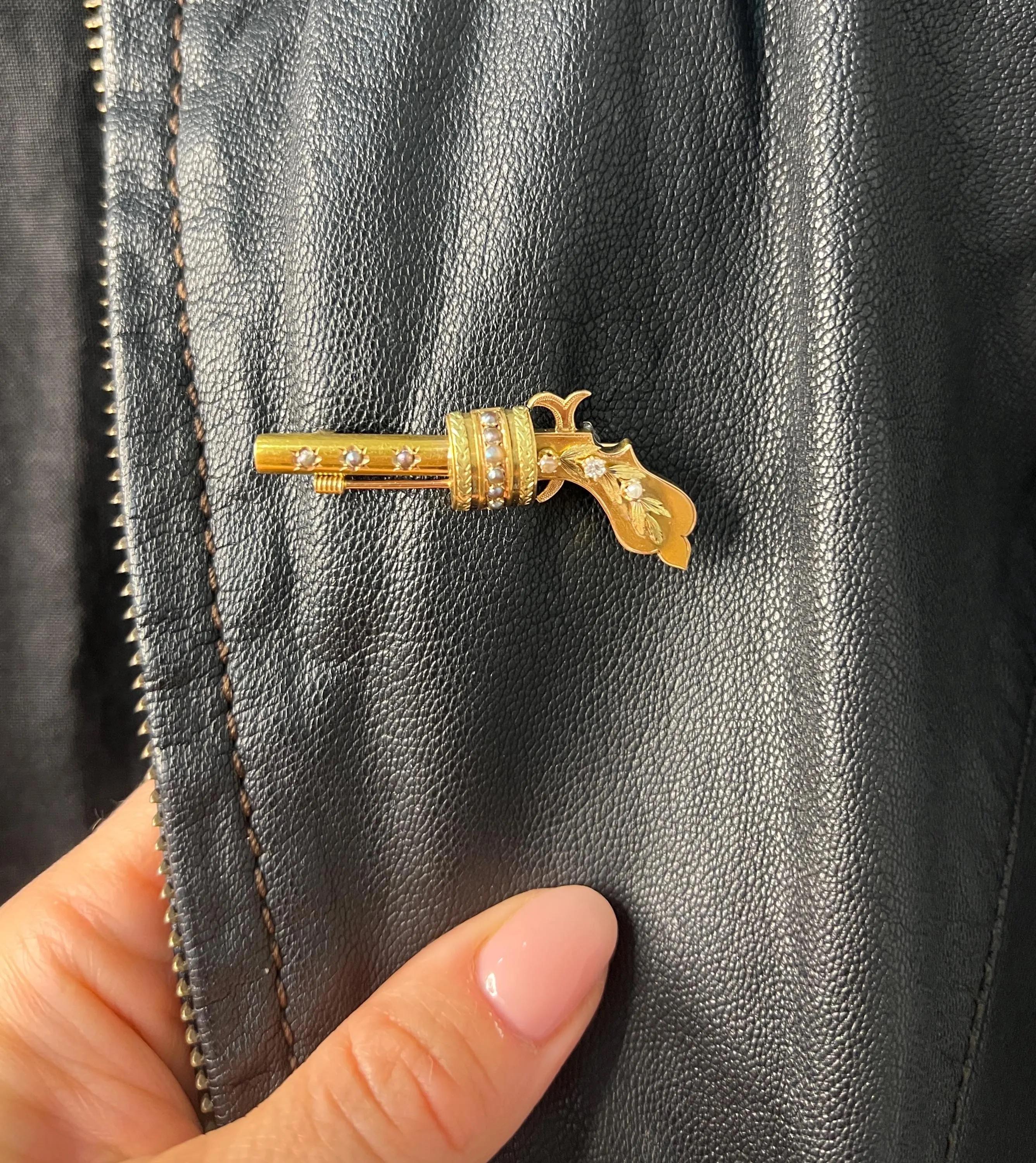 Antique Gun Brooch

18ct Yellow Gold

Circa 1910s

Behold this striking 18ct gold Edwardian-era pistol brooch, a unique and elegant piece adorned with natural seed pearls and a single natural diamond. This fabulous brooch captures the essence of its