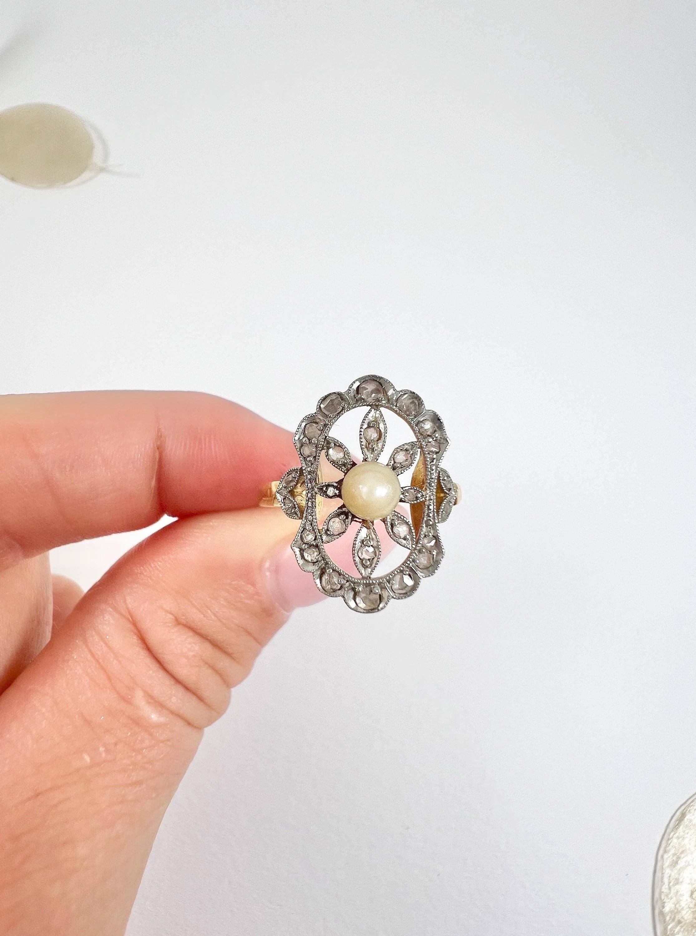 Antique Pearl & Diamond Ring

18ct Yellow Gold & Platinum

Circa 1910

Introducing a breathtaking piece from the Edwardian era, this 18ct yellow gold ring features a fabulous open work design with a stunning pearl and Rose Cut diamond flower at its