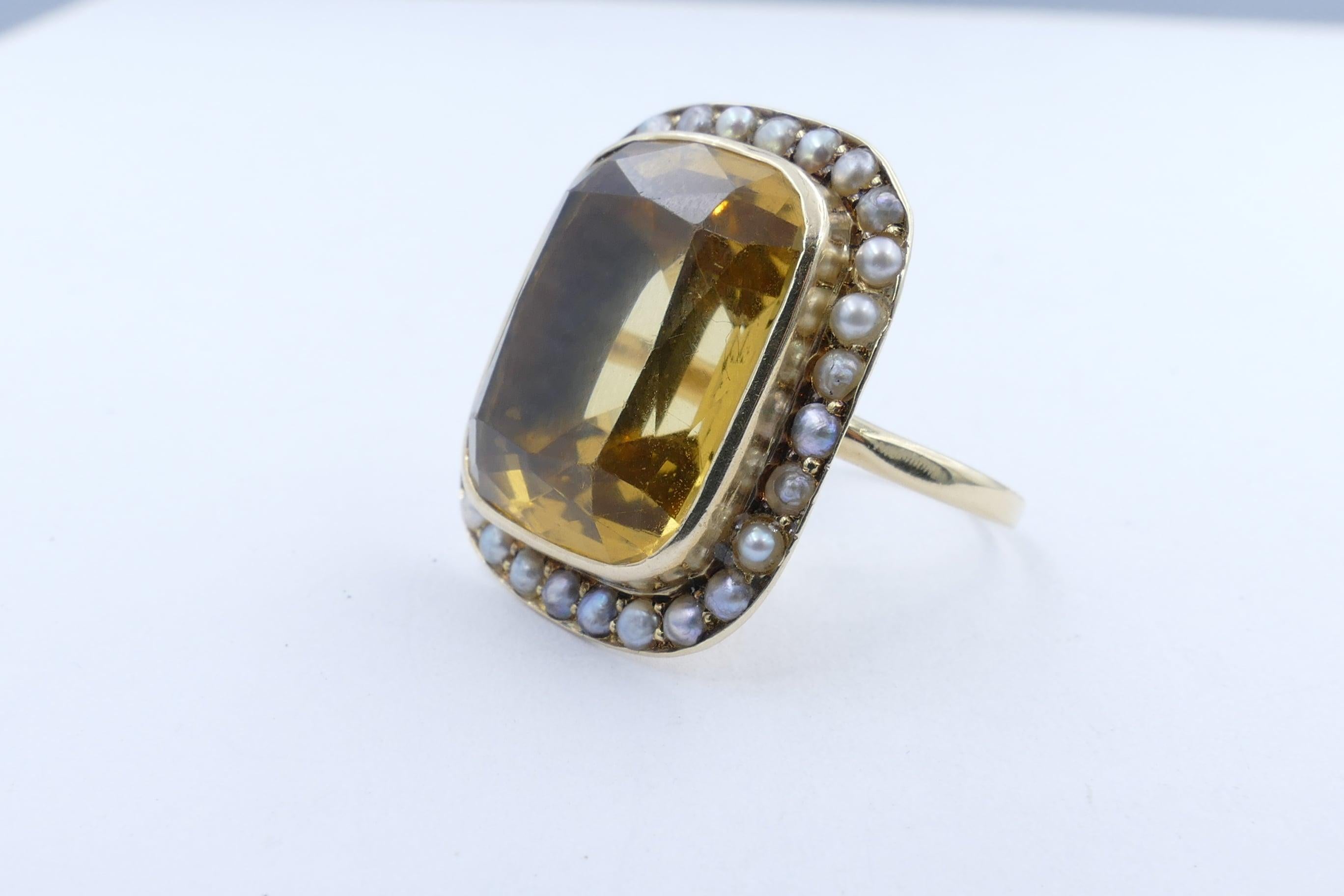 This very pure, and of a beautiful mid yellow colour, eye clean, large Citrine - close to 16 Carats - is rectangular cushion cut, bezel set.  It is surrounded on all sides with 28 Seed Pearls of a white colour with silver overtones & bead set.
It is