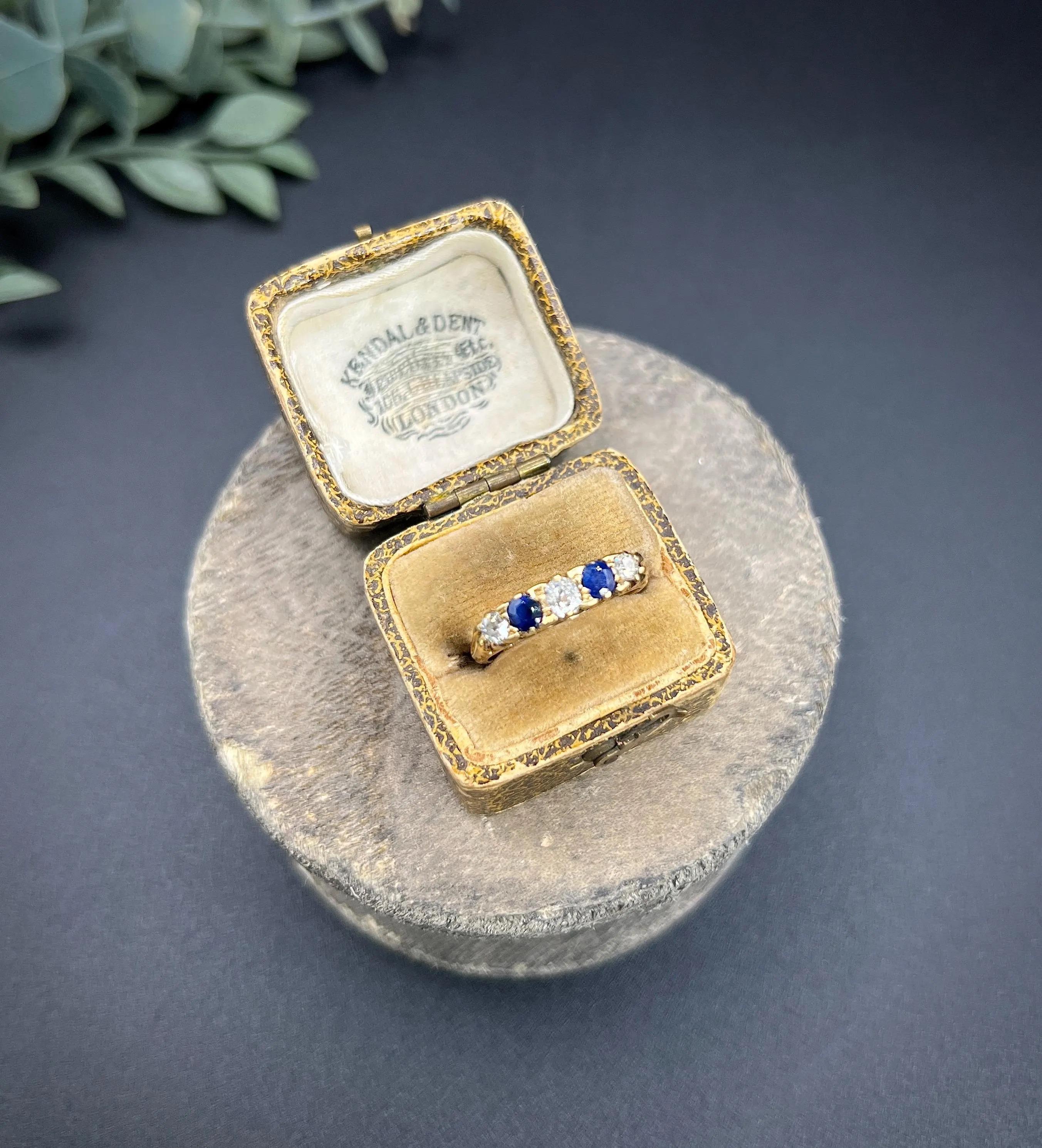 Antique Sapphire Ring 

18ct Gold

Circa 1880

Experience the grace of this exquisite Victorian five-stone ring, expertly crafted from 18ct yellow gold. This exceptional piece features a stunning hand-carved setting that beautifully showcases