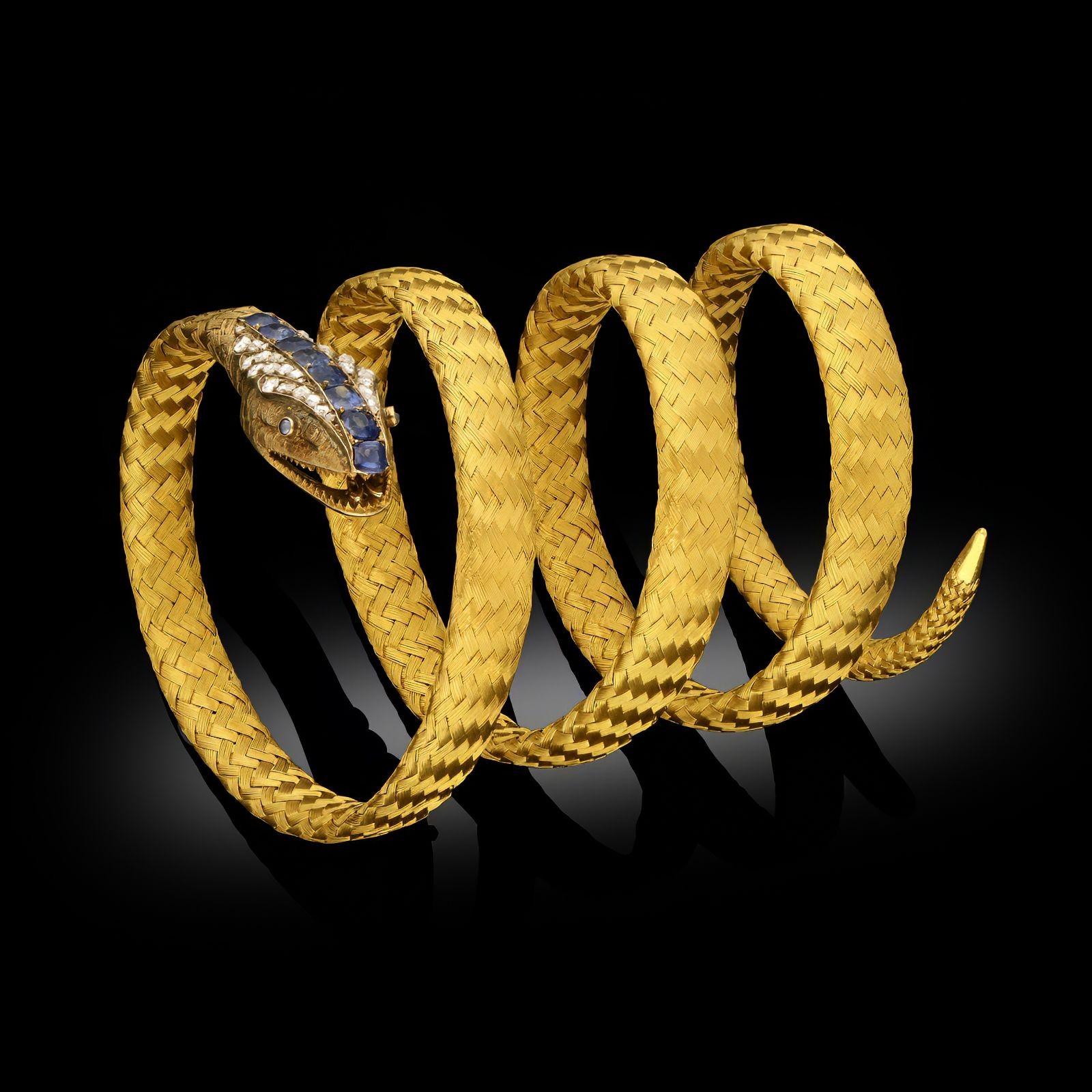 An antique French yellow gold and gem set snake bracelet, circa 1880. The bracelet is designed to wrap around the wrist, the woven 18ct yellow gold braided to be highly flexible, one end featuring a snake’s head with open mouth and engraved