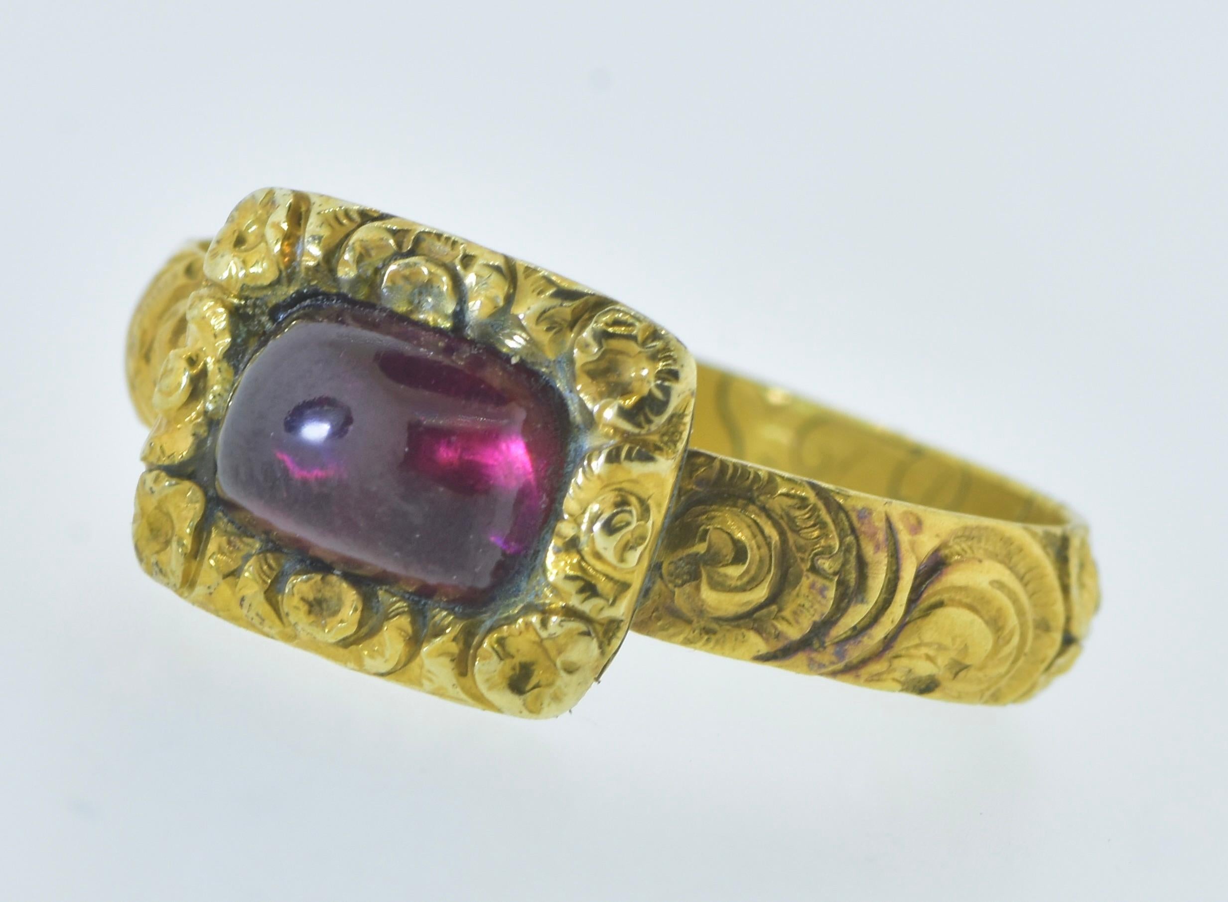 Antique 18K yellow gold and garnet ring, exquisitely engraved in the interior of the band: Thomas Nixon lived Nov 1712 -Oct. 65.  This yellow gold ring is in excellent condition as evident of the fine crisp chased repousse work and the legibility of