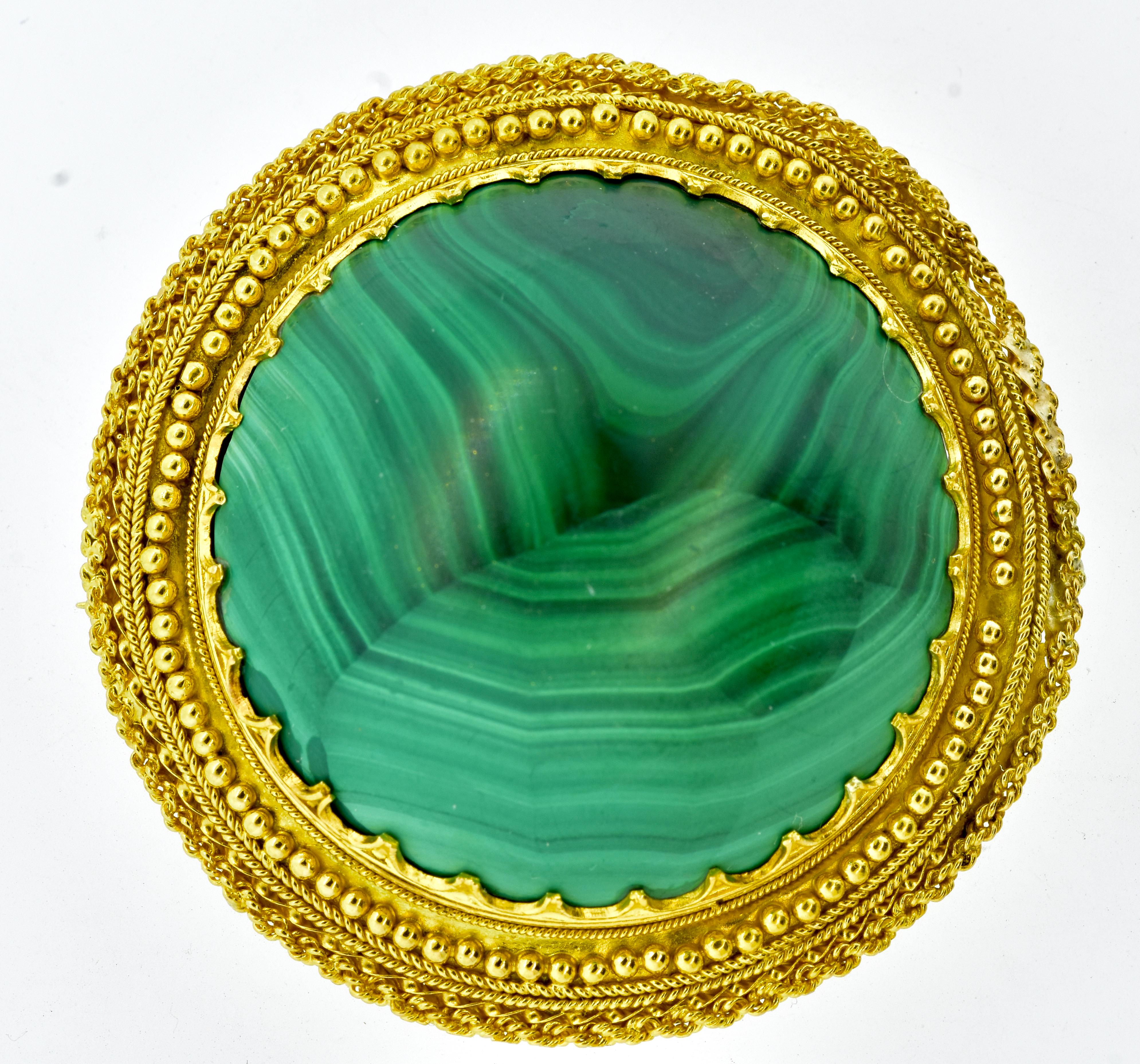Antique 18K and Malachite large brooch, last quarter of the 19th century, this piece has wonderful Etruscan revival gold bead and wire work along the periphery on the large natural bright green Malachite held by ornate prongs.  This is an early hand