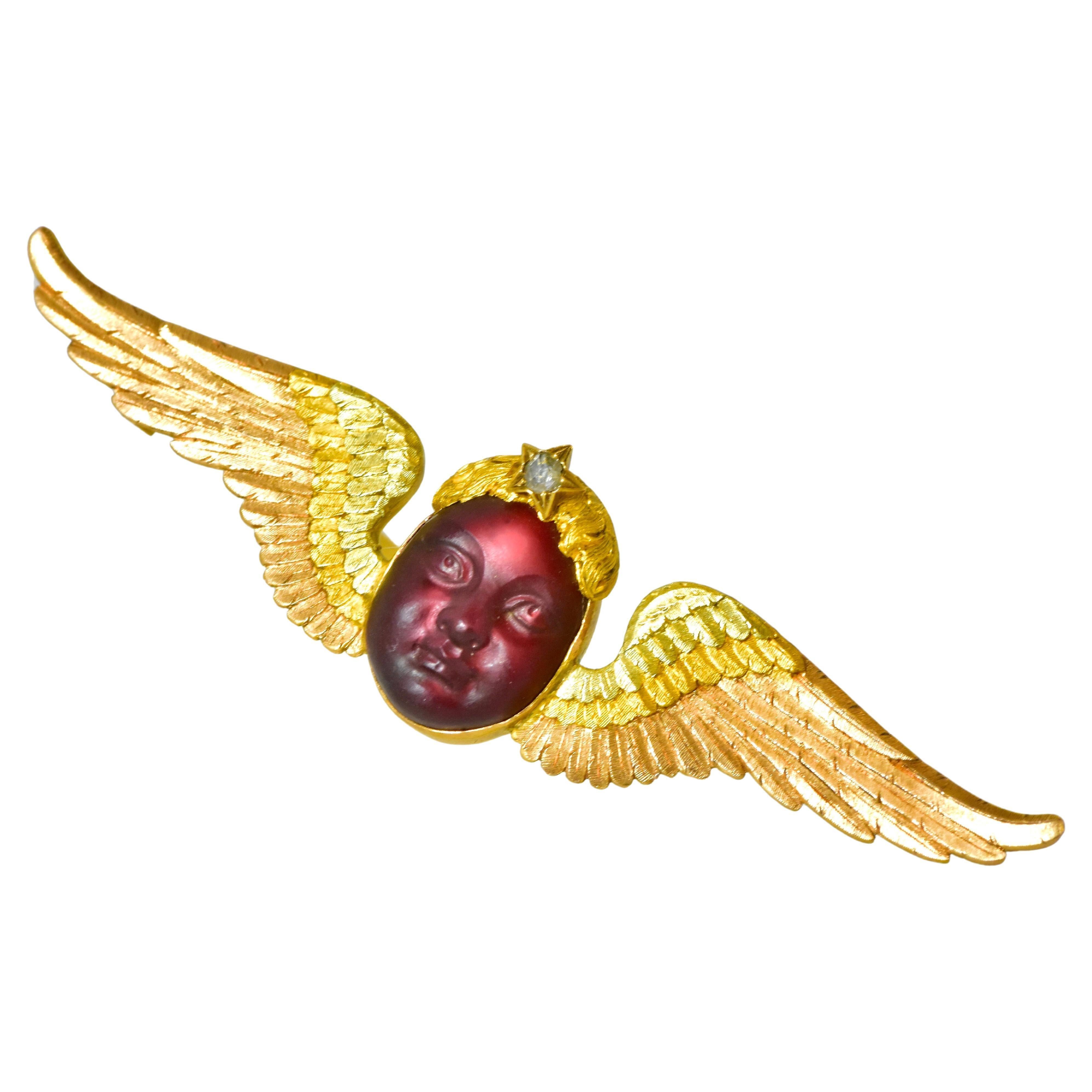 Antique 18K carved garnet of an ethereal representation of a cherub or an enfant. The work is quite three dimensional, right down to its star motif rose cut diamond in the hair. The finely etched wings are in three colors of gold - yellow, pink and