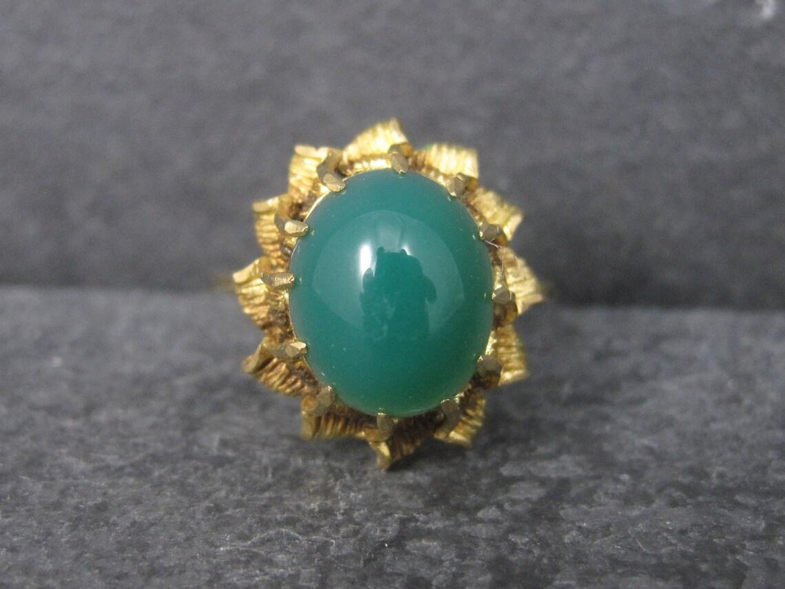 This gorgeous antique ring is 18k yellow gold.

It features a stunning green chrysoprase cabochon.

The face of this ring measures 3/4 of an inch north to south with a rise of 10mm off the finger.
It is a size 8.

Marks: 0750 (18K gold)

Condition: