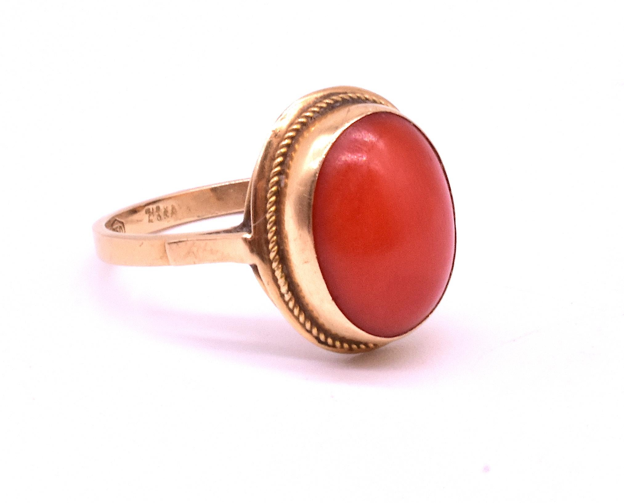 Antique 18K yellow gold ring with a 5/8 inch diameter round, beautifully colored smooth cabochon coral at the center and millegrain detail in the gold border. 
A classic, simple pretty Victorian coral ring from the 1880's. The ring is a size 7.