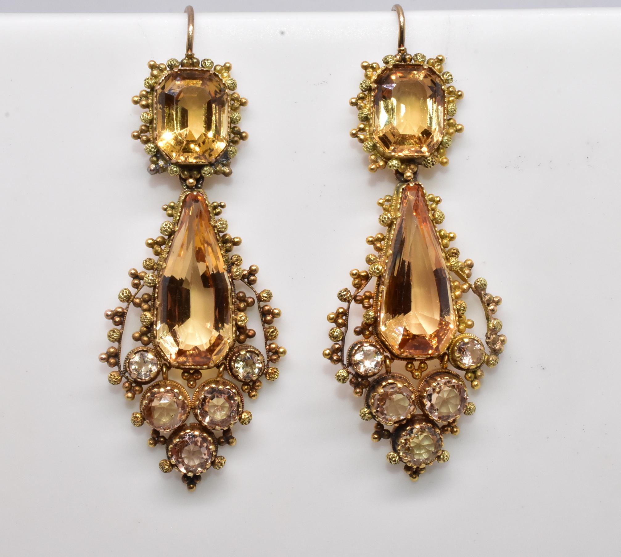 A fabulous pair of Georgian pendant earrings composed of Imperial topaz, brilliant cut diamonds and 18k gold, these would have been worn on the most elegant of occasions. The extensive facets and open mount setting maximize the light and give them