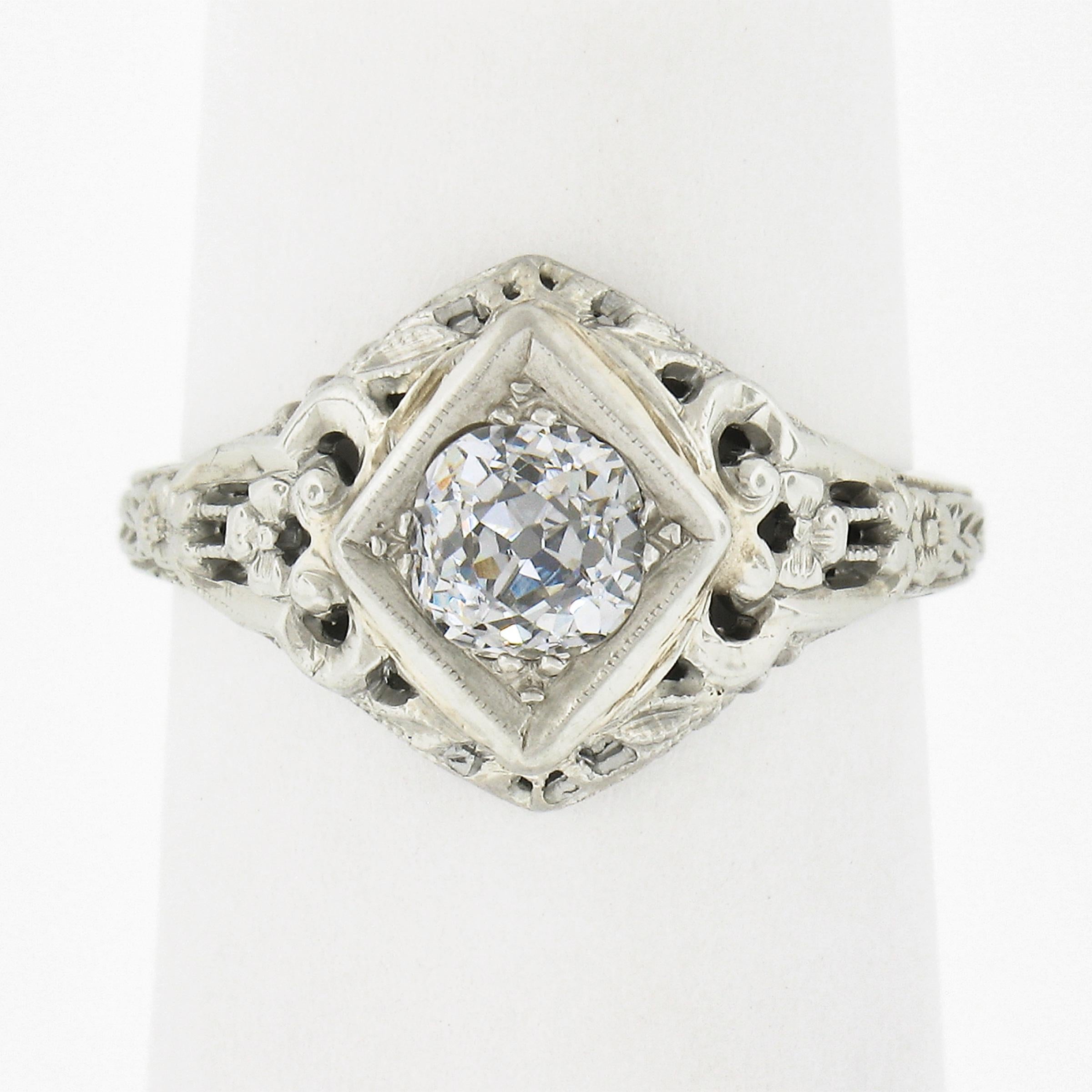 This stunning art deco engagement ring is crafted in solid 18k white gold and features an approximately 0.60 carat diamond solitaire bead set in a rhombus shaped setting at the center of the slightly puffed design. This gorgeous chunky diamond is