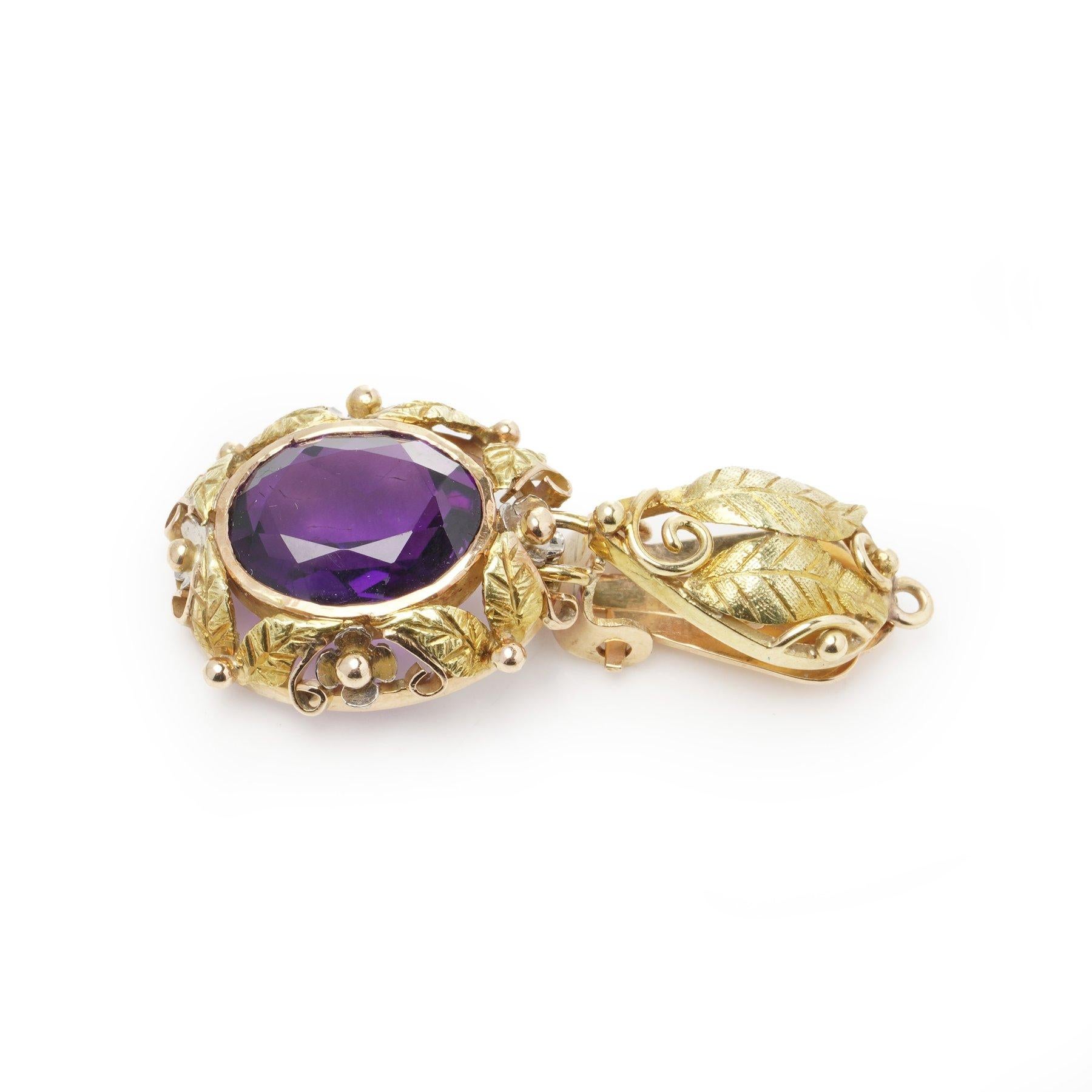 Uno splendido paio di antichi orecchini a clip in oro 18 carati con due vibranti ametiste dal taglio ovale incastonate in cornici d'oro ornate e ispirate alla natura. L'intricato design presenta motivi di foglie incise, delicate perline e volute