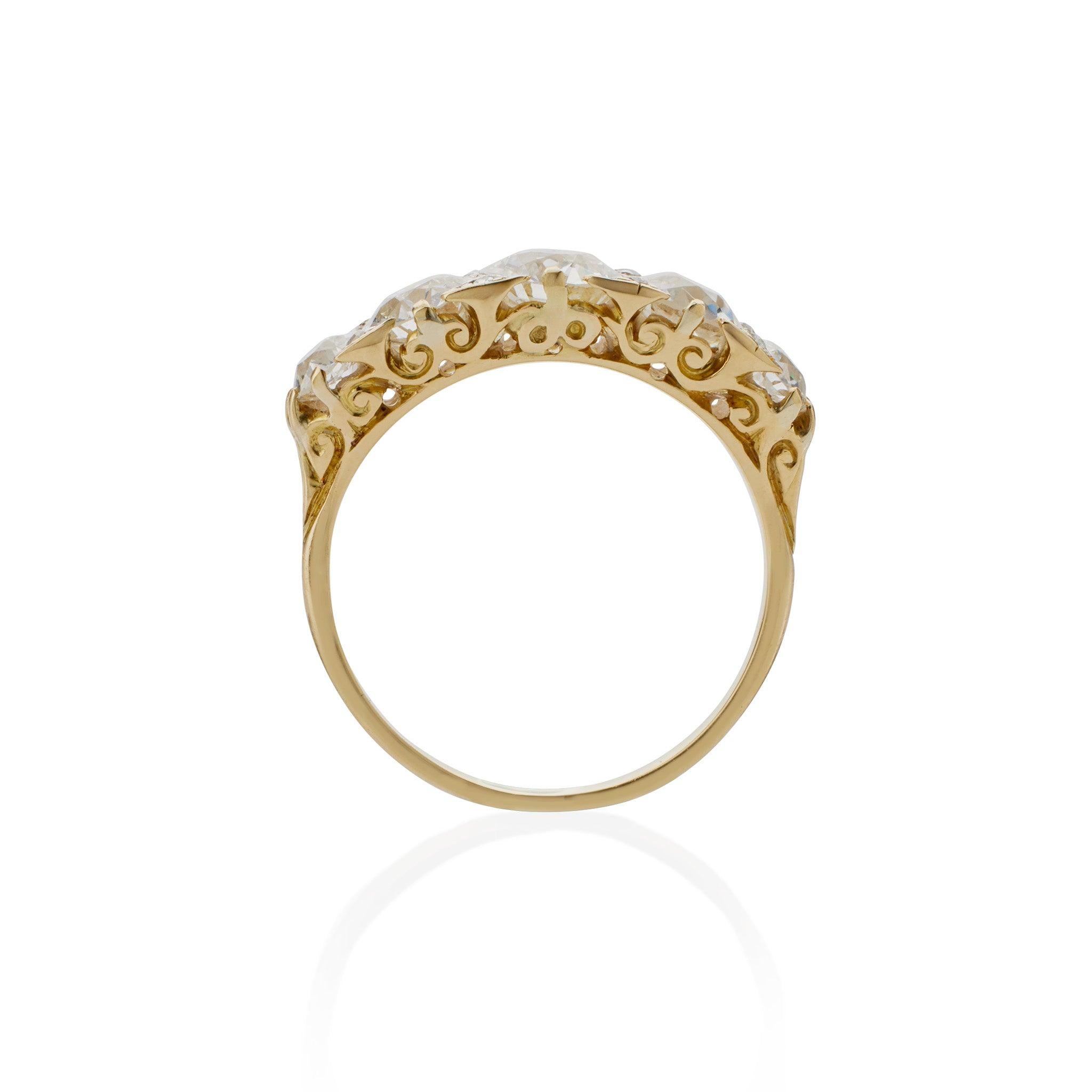 This antique diamond ring is composed of five old European-cut diamonds, approximate total weight 2.30 carats, set in gold with a delicately scrolling gallery. Interspersed with additional smaller rose-cut diamonds to fill every possible space among