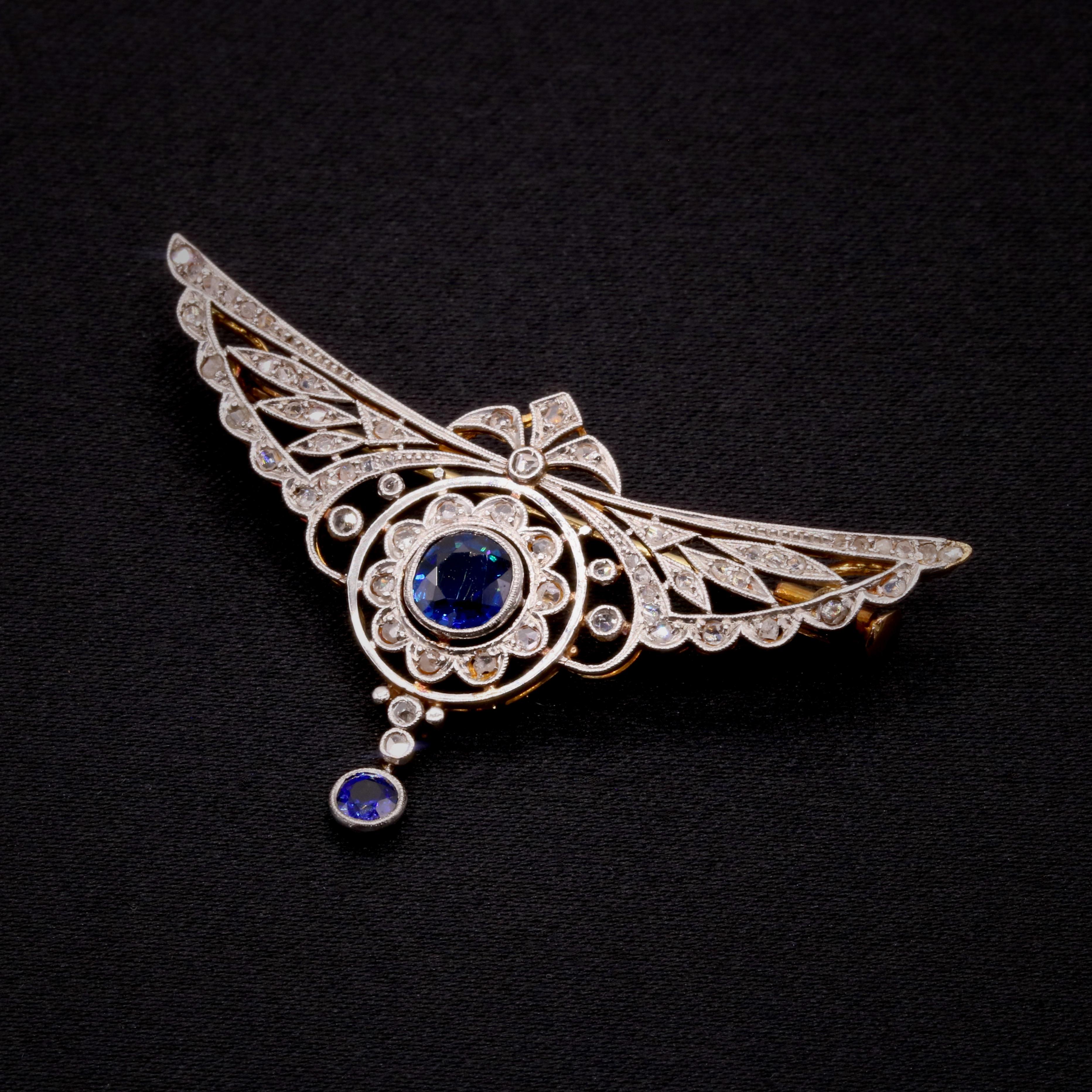 A yellow gold and platinum brooch/pendant, comprising of two round cut sapphires, studded with fifty-six rose cut diamonds, set in an openwork winged design of platinum atop 18k yellow gold. 

This stunning 18 karat yellow gold and platinum brooch