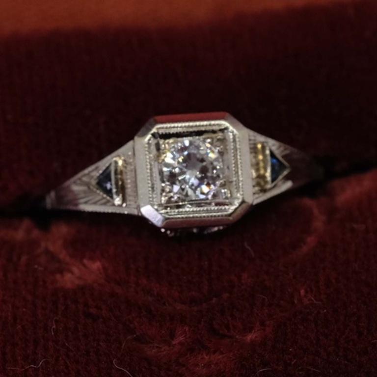 One-ladies Antique 18K gold ring with central round brilliant cut diamond in prong setting. Each shoulder is set with sapphires. Ring size 5