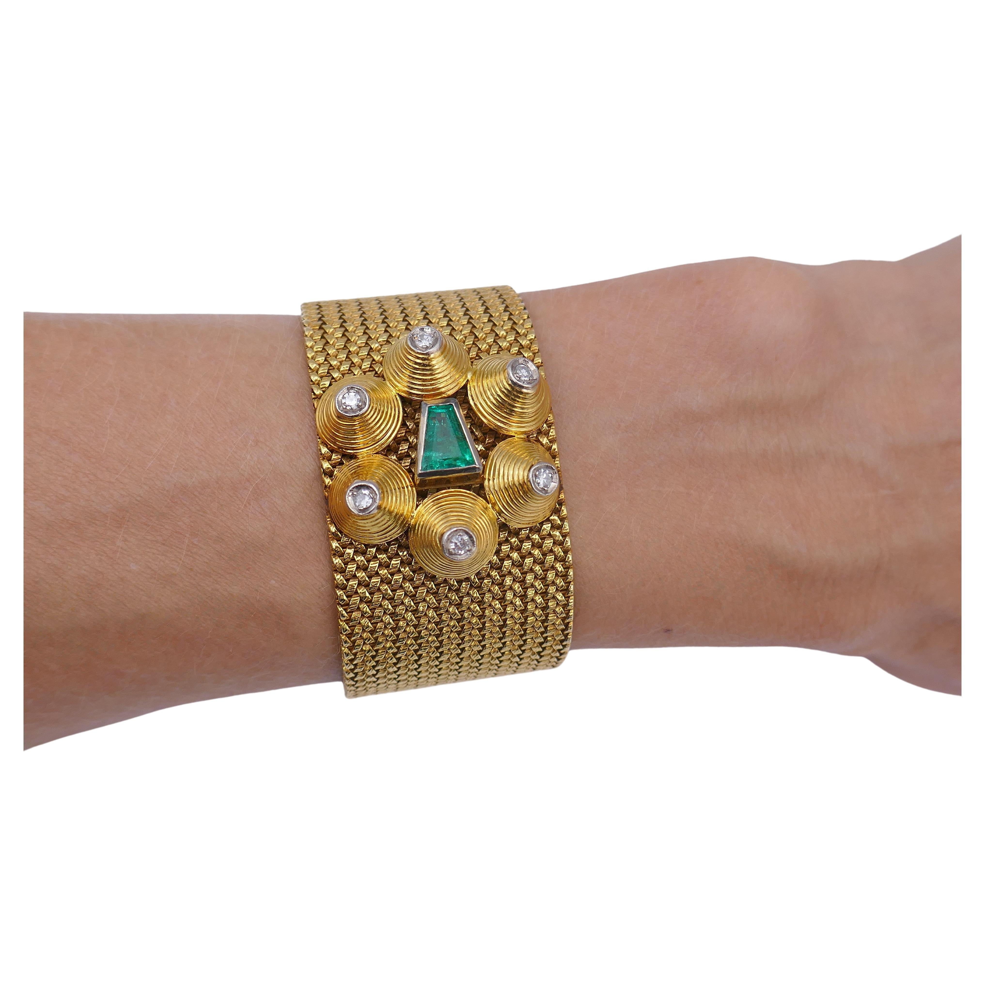 A fantastic antique 18k gold mesh bracelet, featuring emerald and diamond.
The bracelet is adorned with a unique geometric pattern comprises a circle of 6 gold pyramids. Each pyramid it topped with a diamond. In the center of the circle there is a