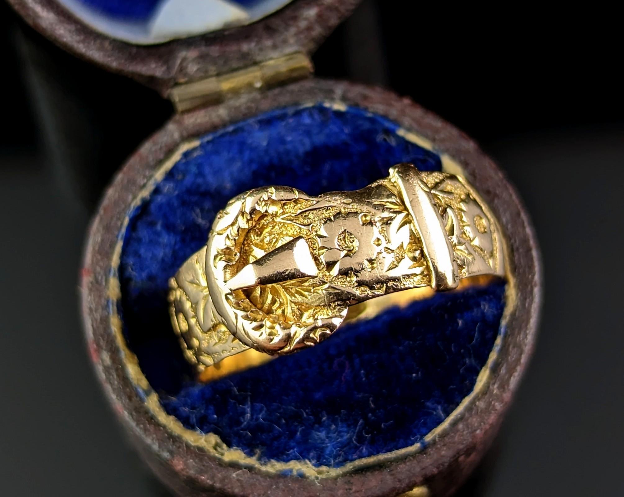 Diese atemberaubende antike 18kt Gold graviert Buckle Ring ist so reich und bezaubernd.

Das butterweiche Goldband ist stark ziseliert und mit einem Orangenblütenmotiv graviert und hat eine Schnalle auf der Vorderseite. Die Schnalle symbolisiert