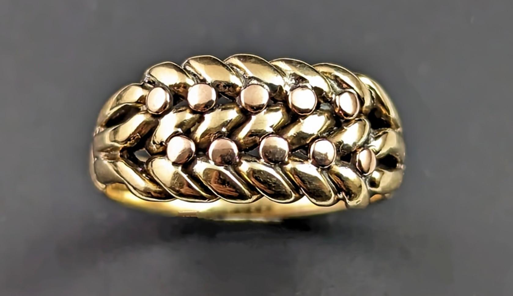 The keeper ring is a classic and highly sought after ring style, always in high demand and this antique Edwardian era 18k gold keeper ring is one of our favourites.

The face is made up from a scrolling knot with rose gold beading, this ring is very