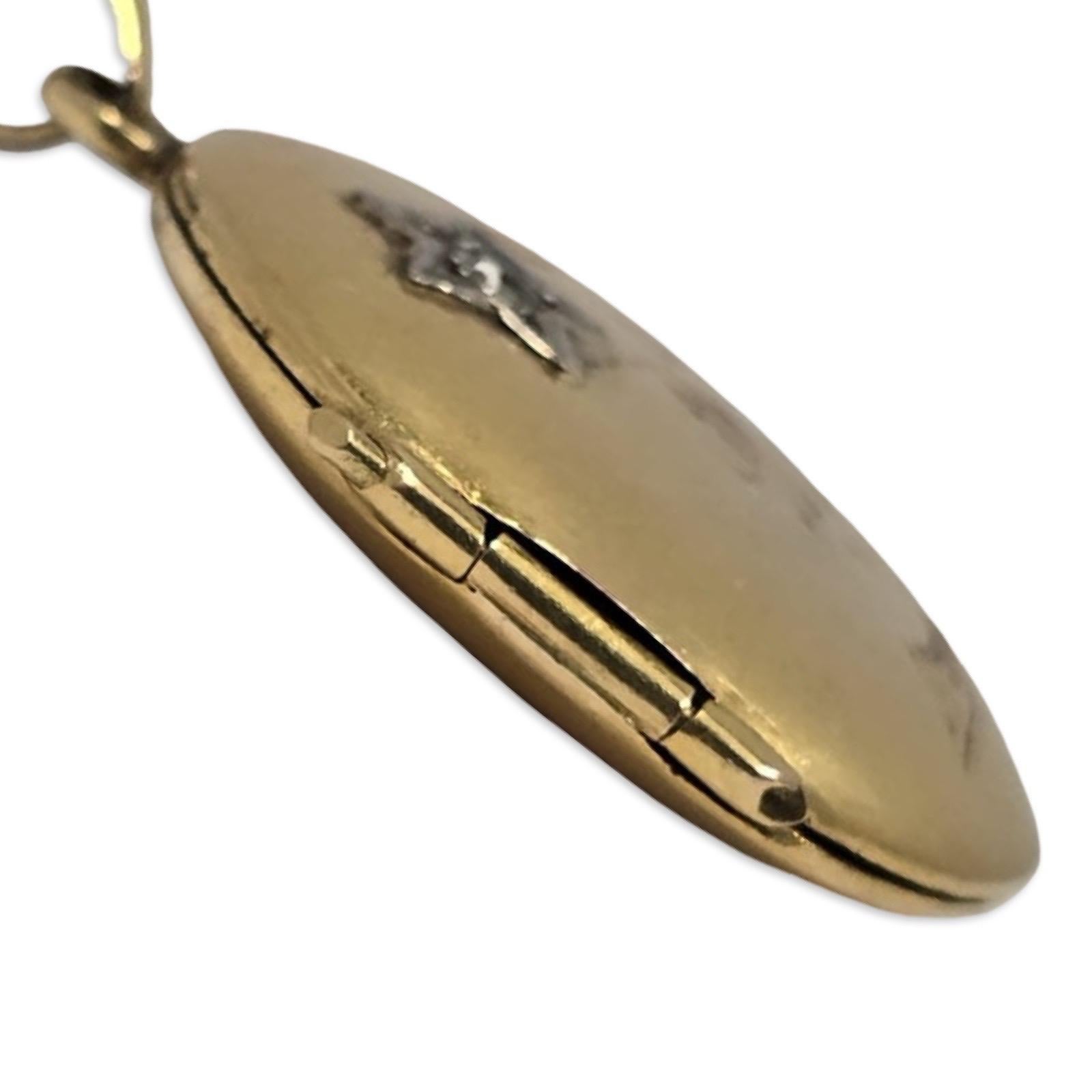 Charmant pendentif médaillon ancien en or 18 carats, orné d'un motif floral gravé à la main et d'un étincelant diamant de taille européenne serti dans un motif en étoile. La douce chaleur de l'or fin et la gravure romantique reflètent le sentiment