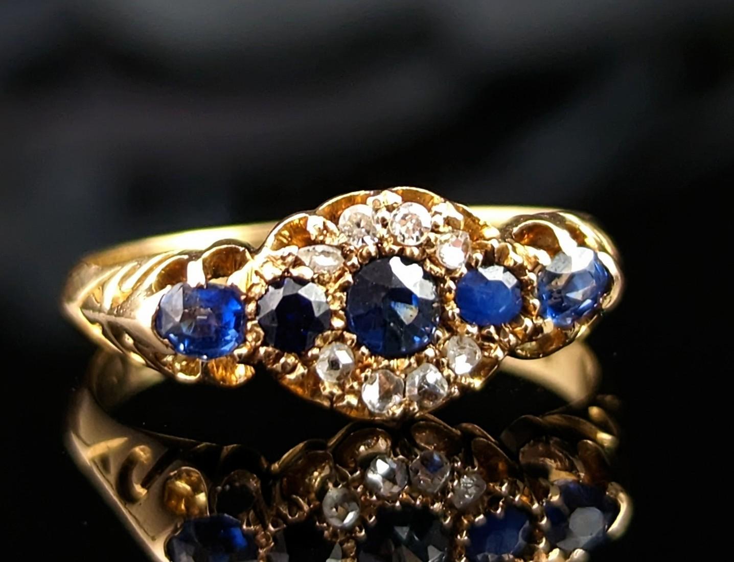 This stunning antique, Edwardian era, Sapphire and Diamond cluster ring is a simply a dream.

Crafted in rich 18kt yellow gold this ring has a central floral shaped cluster with a vibrant blue round cut sapphire to the centre surrounded by a halo of