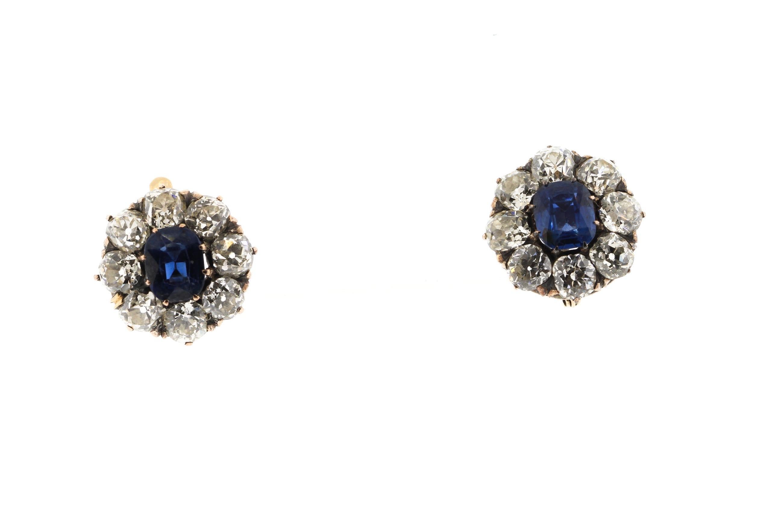 A pair of antique old mine diamond and sapphire cluster earring circa 1890. This is a wonderful and classic model of earring, and very easy to wear. The earrings center on a bright blue sapphire each weighing about a carat. They have been tested by
