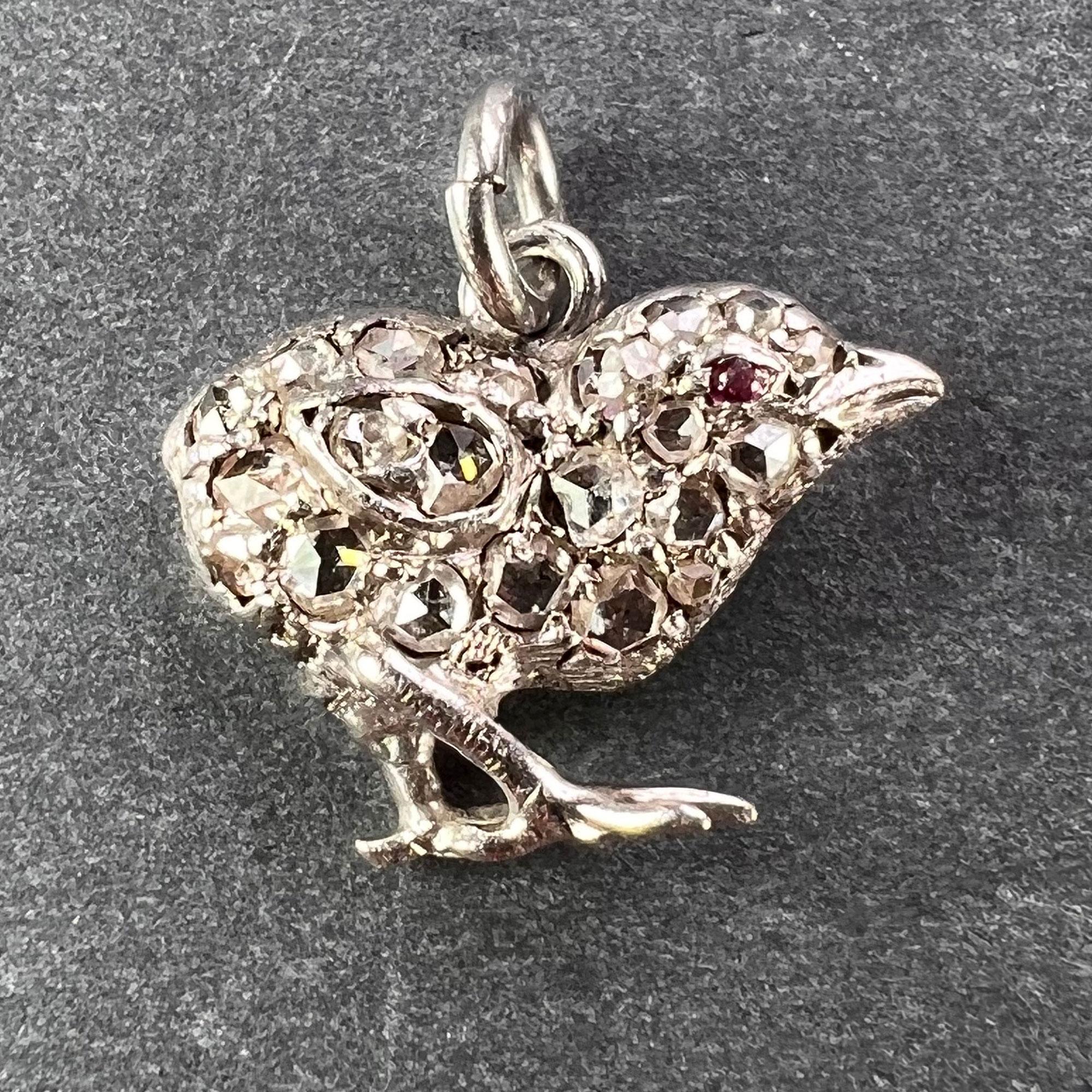 Un antico ciondolo a forma di pulcino in oro e argento con 21 diamanti taglio rosa per un peso totale stimato di 0,32 carati e un occhio di rubino cabochon. Non segnato ma testato come oro rosa 18 carati (18K).

Dimensioni: 1,2 x 1,4 x 0,4 cm 
Peso:
