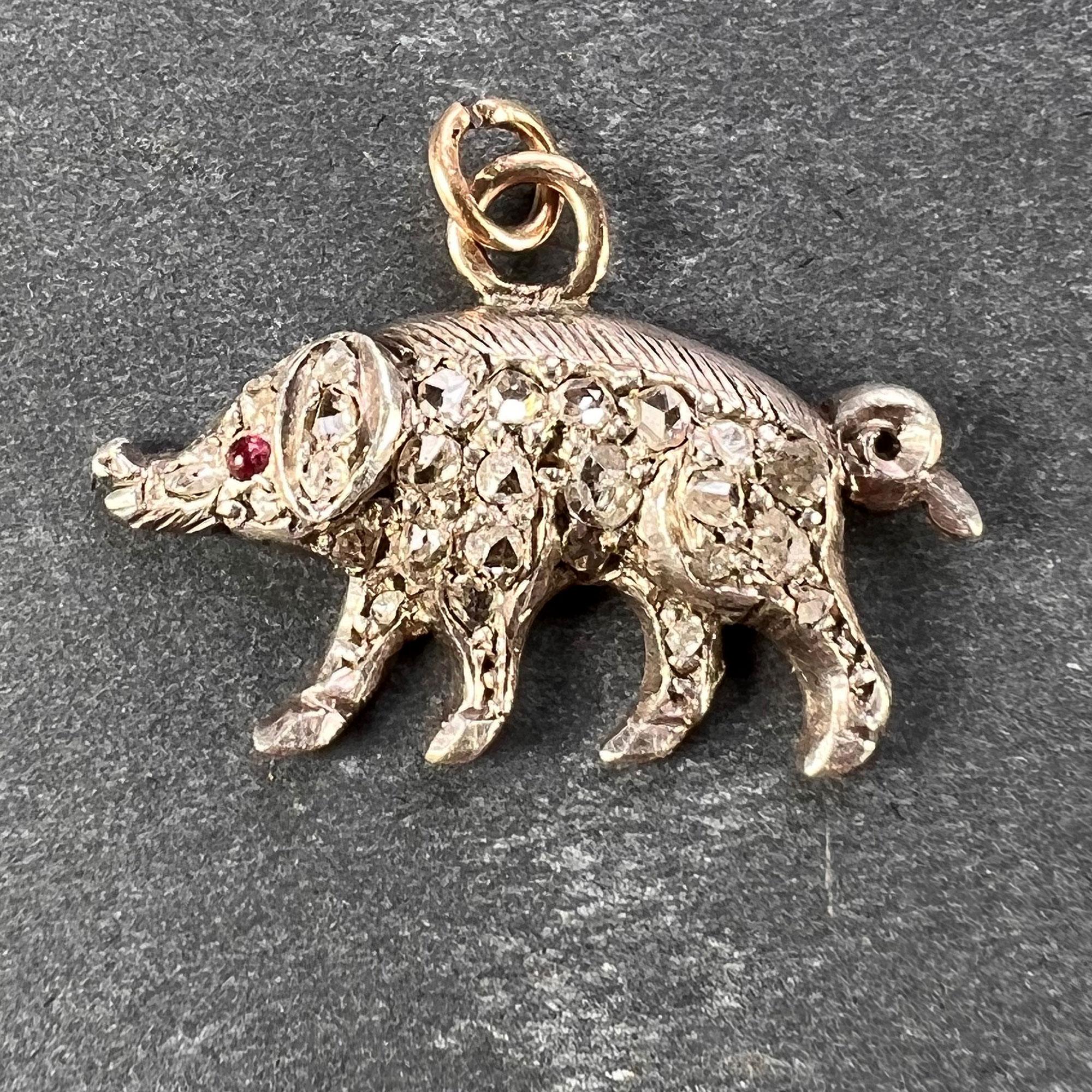 An antique charm pendant designed as a pig in gold and silver set with 26 rose-cut diamonds with an estimated total weight of 0.40 carats and a cabochon ruby eye. Unmarked but tested as 18 karat (18K) rose gold with scratch numbers to the