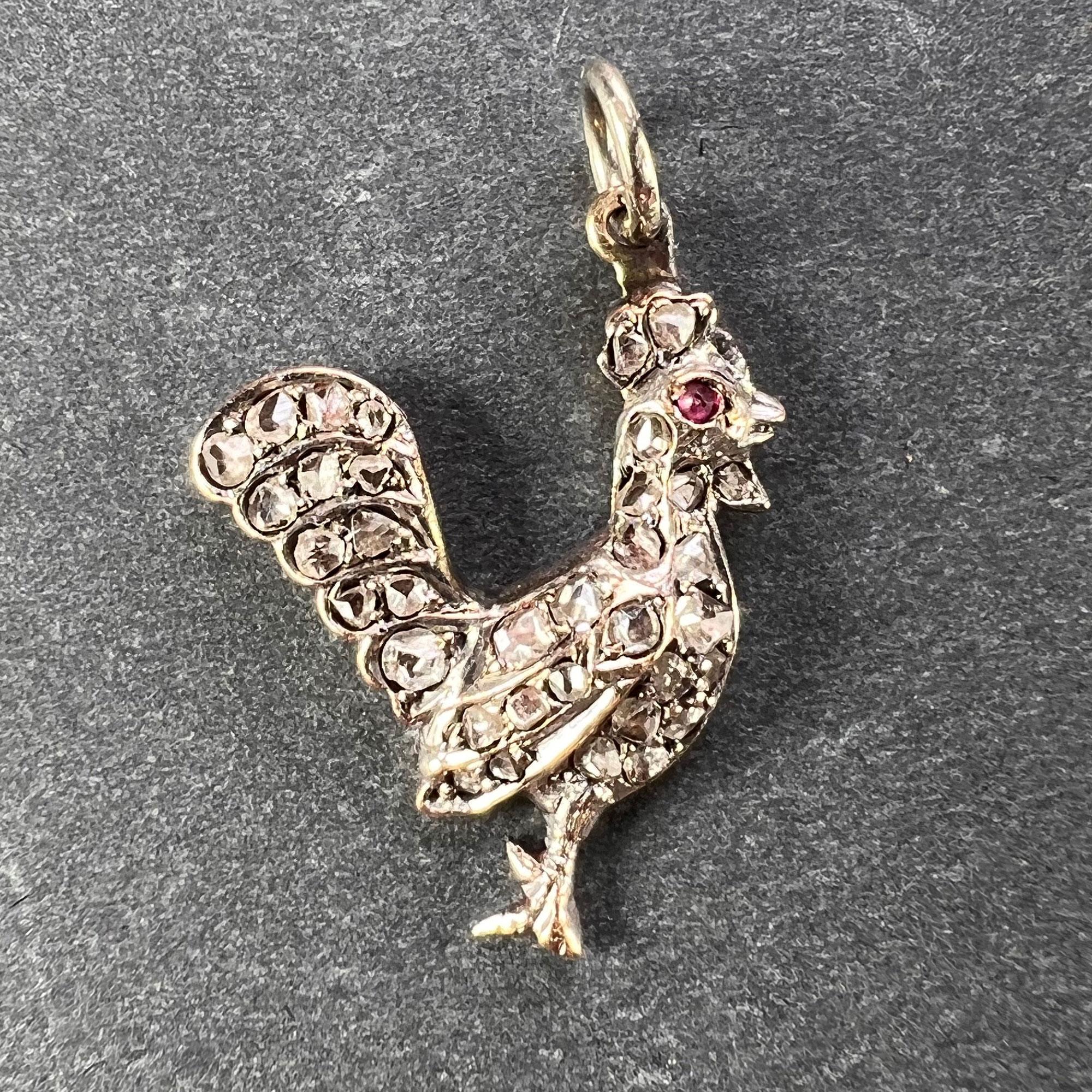 An antique charm pendant designed as a rooster in gold and silver set with 35 rose-cut diamonds with an estimated total weight of 0.35 carats and a cabochon ruby eye. Unmarked but tested as 18 karat (18K) rose gold with scratch numbers to the
