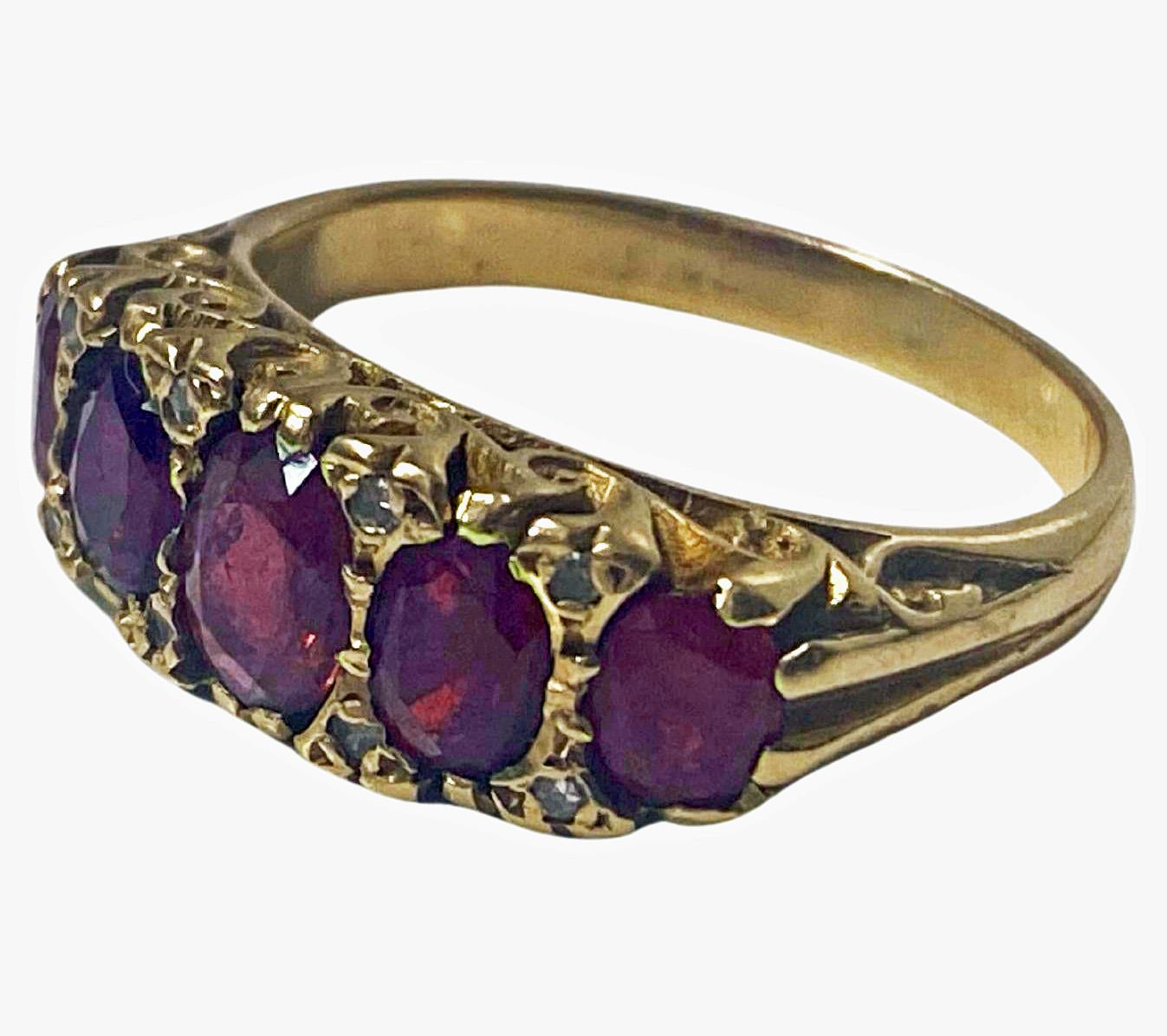 Antique Victorian five stone half hoop Ruby and Diamond 18K Ring, C.1890 The Ring comprising of five graduated oval faceted Purple Red Rubies, weighing a total of approximately 3.00 ct. accented at each corner with a small rose cut diamond. The