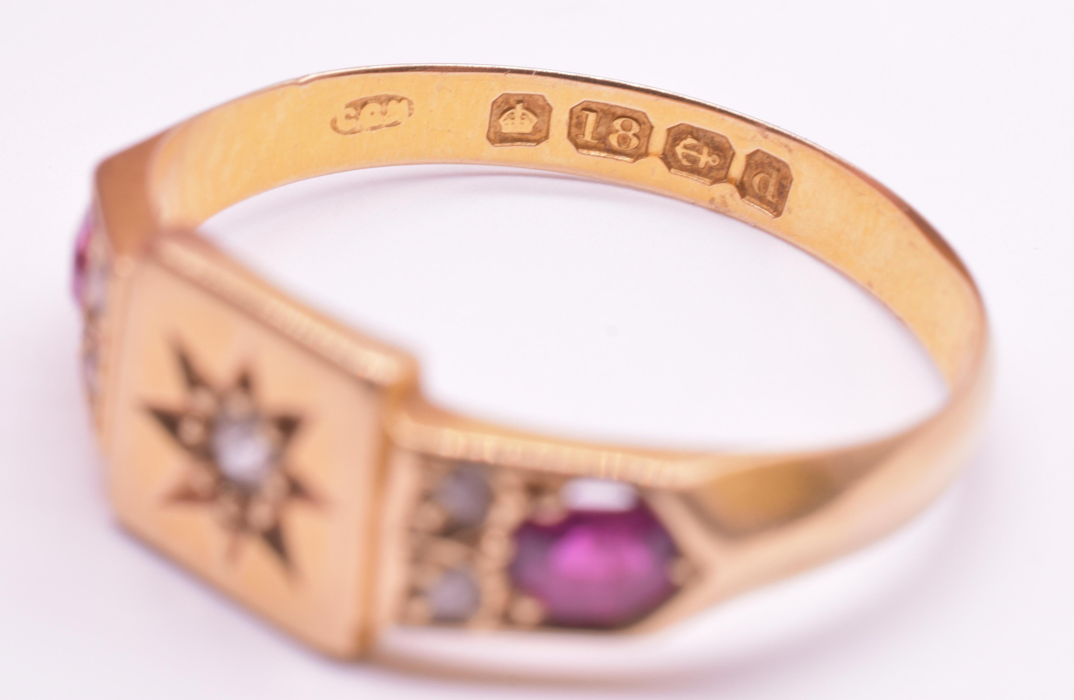 Klassischer viktorianischer Rubin- und Diamantring mit einem sternförmig gefassten Diamanten in einem Quadrat, versetzt mit 2 kleineren Diamanten und einem einzelnen Rubin. Die Facetten der Steine und des Goldbandes greifen die Geometrie der
