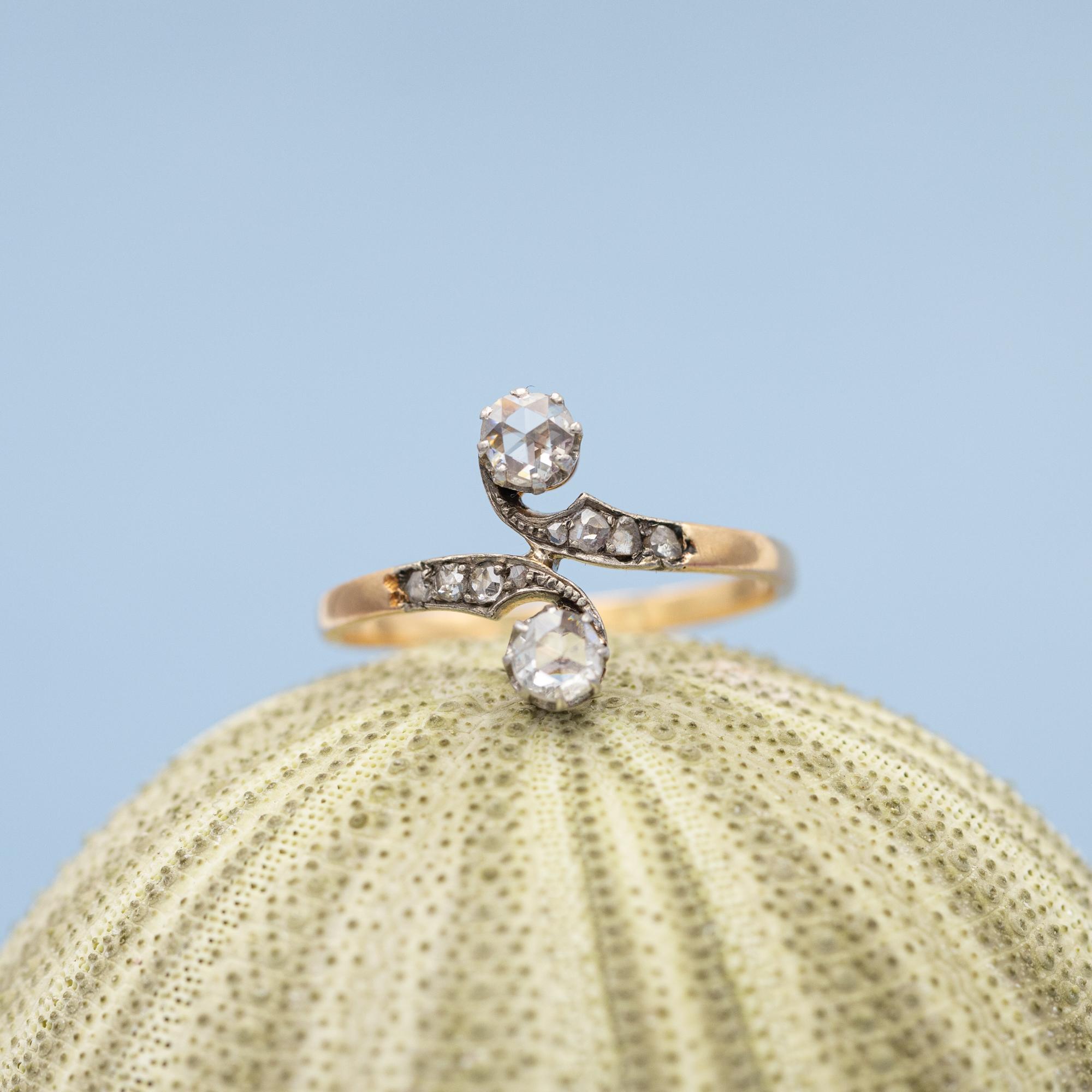 This extraordinary French ring is crafted in 18 karat yellow gold and finished with white rhodium, like mostly done with antique rings crafted around this late victorian era. This stunning 'toi et moi' -ring is set with two lovely old rose cut