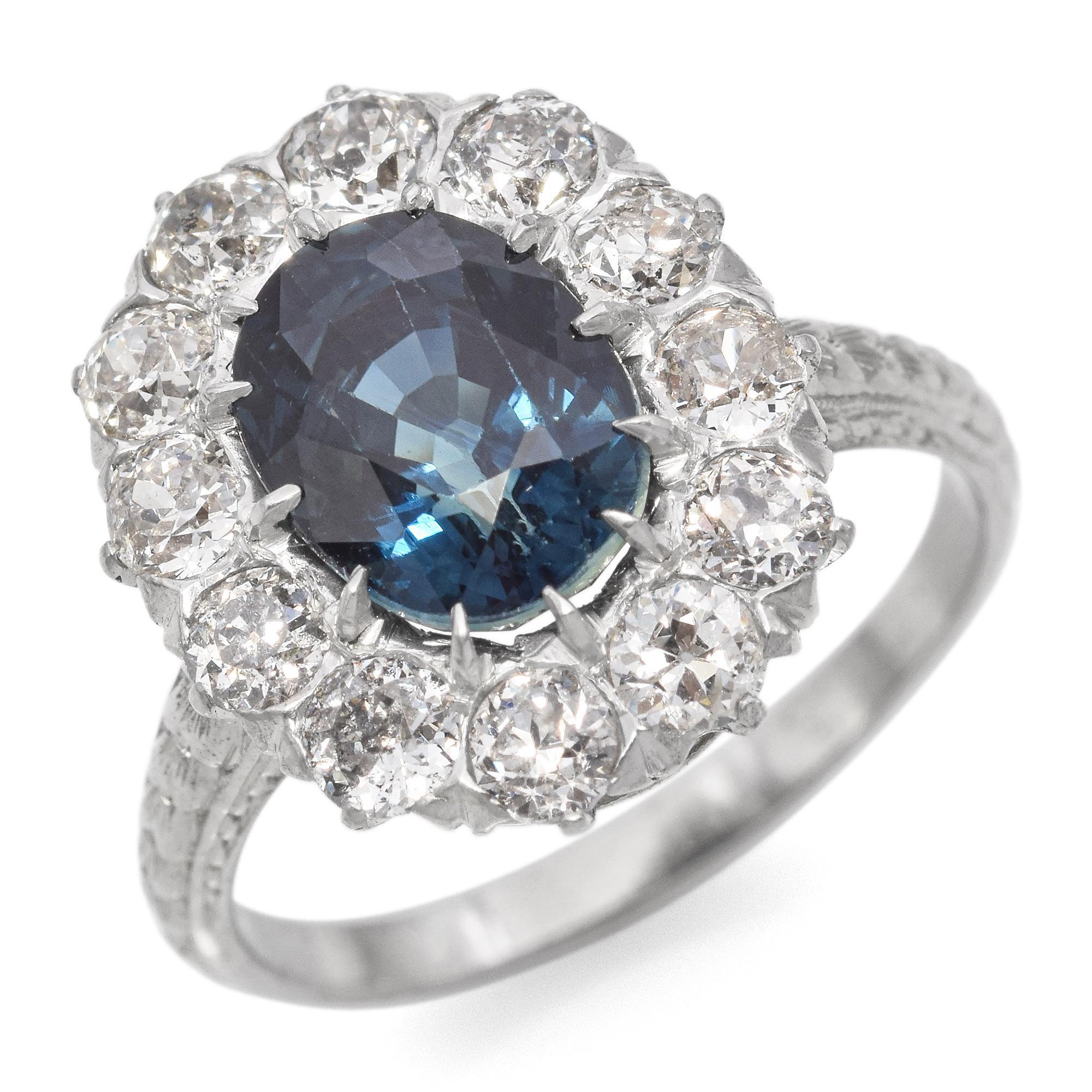 Ein raffinierter und eleganter Ring mit einem auffälligen ovalen blaugrünen Saphir in der Mitte.
Der Saphir ist von einem Halo aus runden Diamanten im alten Minenschliff umgeben, die seinen tiefblauen Farbton betonen.
Dieser exquisite Ring aus 18