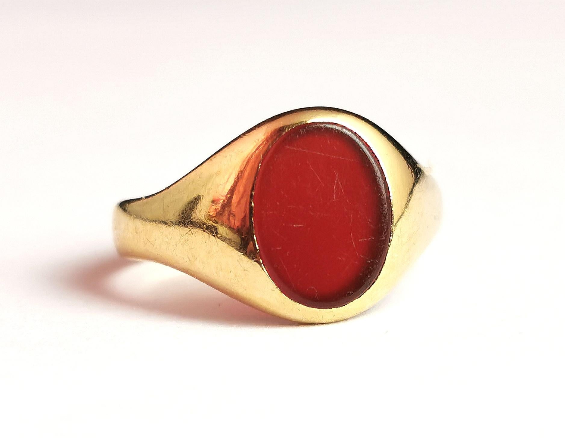 A handsome antique, Art Deco era
18kt gold and Carnelian signet ring.

It has an oval shaped face set with a rich orangey red Carnelian stone, this has not been carved so could be personalised if desired.

It has chunky raised and tapering shoulders