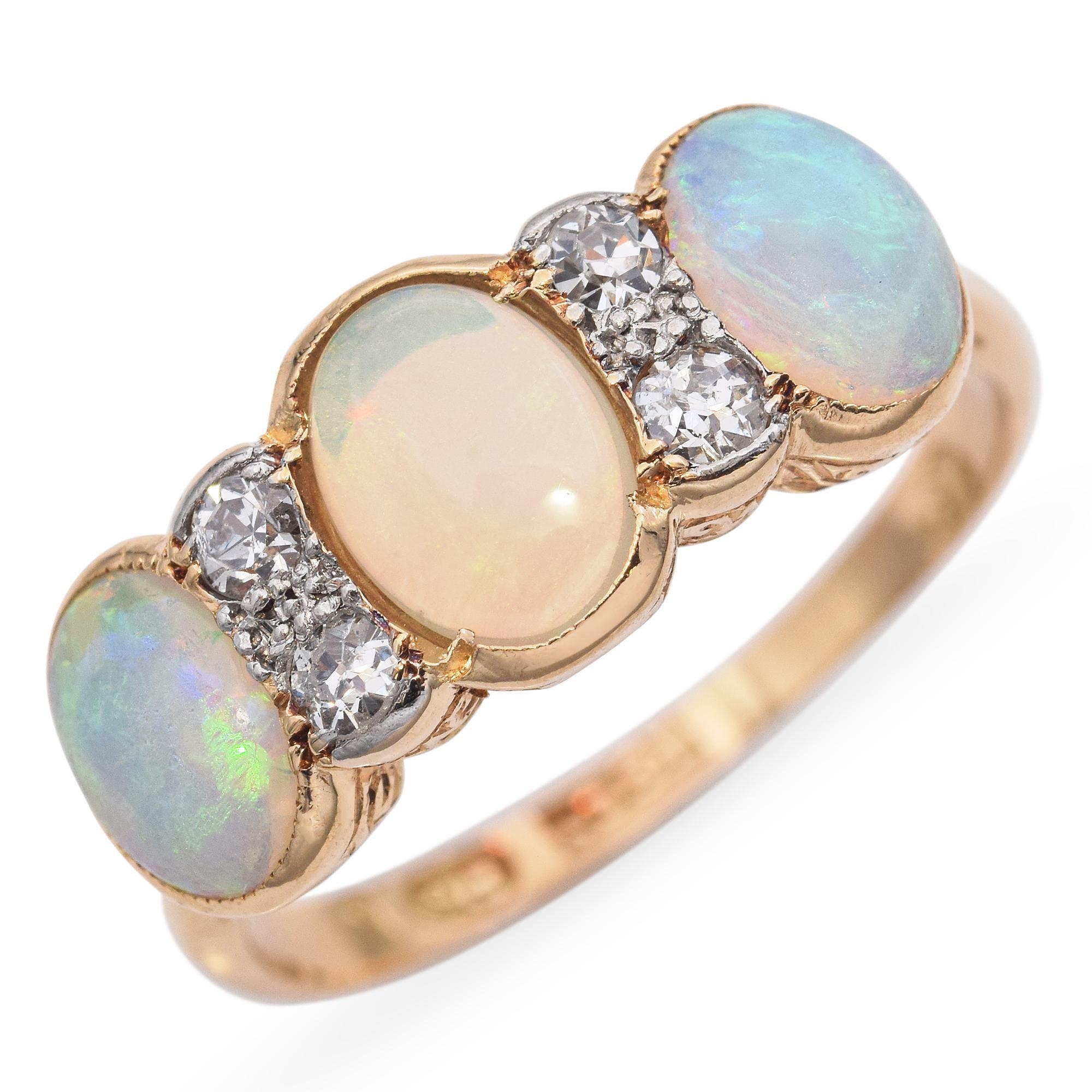 This antique band ring is crafted in rich 18k yellow gold and features a stunning row of opals accented by sparkling diamonds. Each opal displays a beautiful play of color, with flashes of green, pink, and blue that shift in the light. The diamonds
