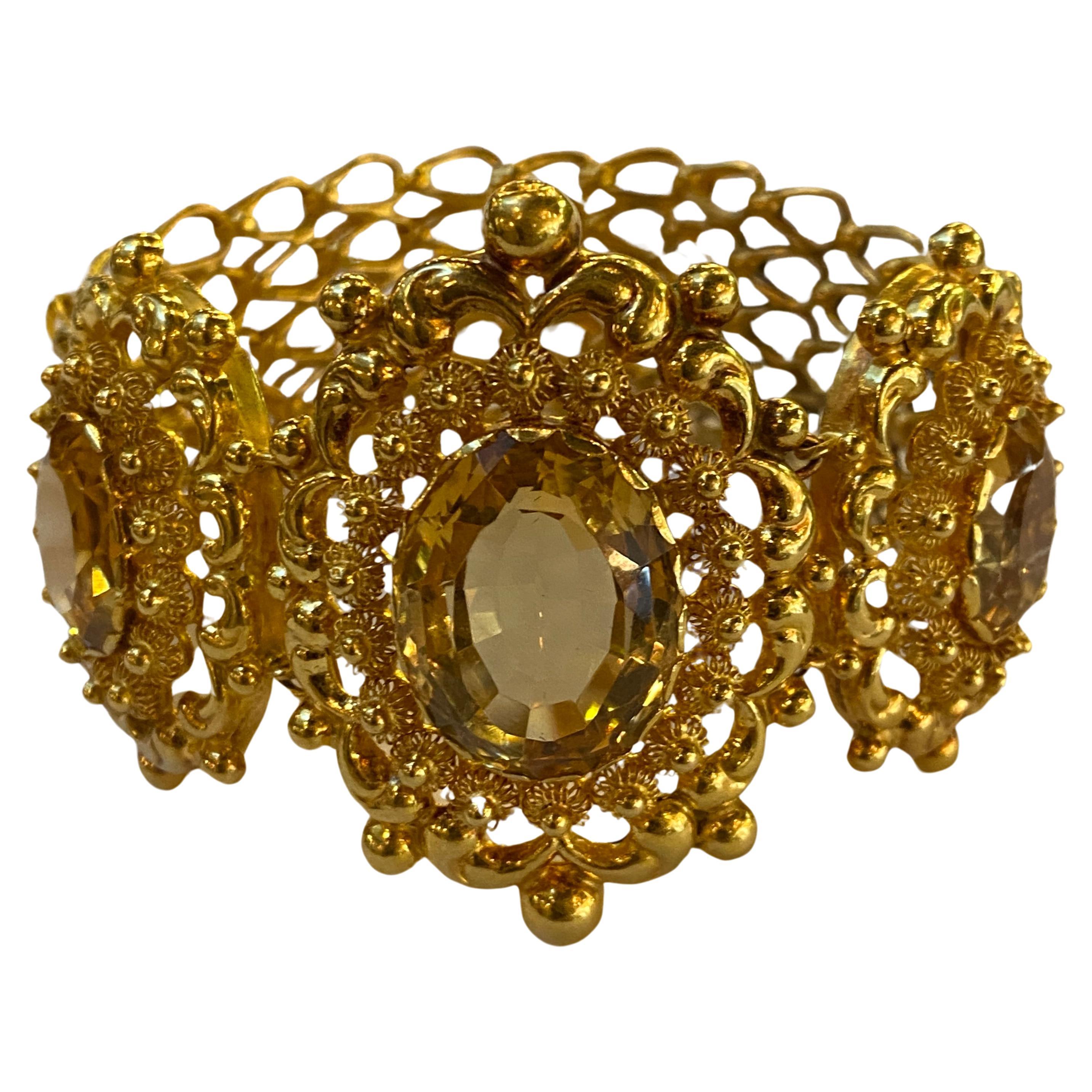 A stunning, fine and impressive 25 carat citrine and 18 carat yellow gold link bracelet

This antique bracelet features three large oval faceted yellow citrines, the largest at 15 carats and the two flanking the center are 5 carats each. Each gem is