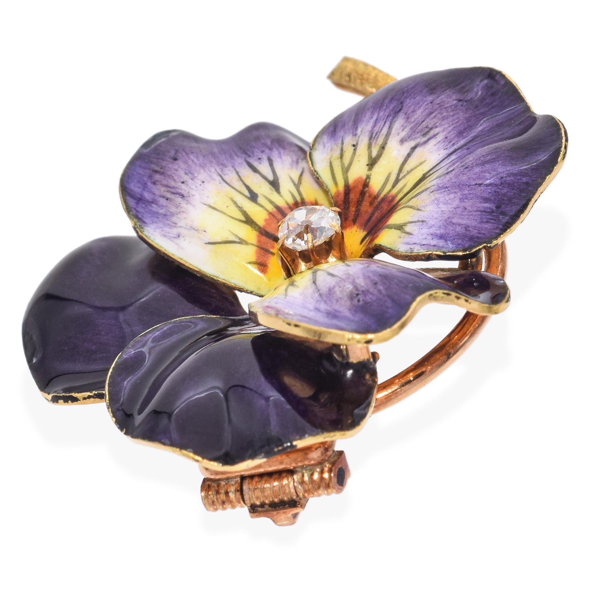 This captivating brooch, meticulously crafted in the form of a vibrant pansy, showcases a stunning blend of deep purple and soft yellow enamel petals. At its heart, a sparkling diamond is nestled, adding a touch of brilliance to the floral