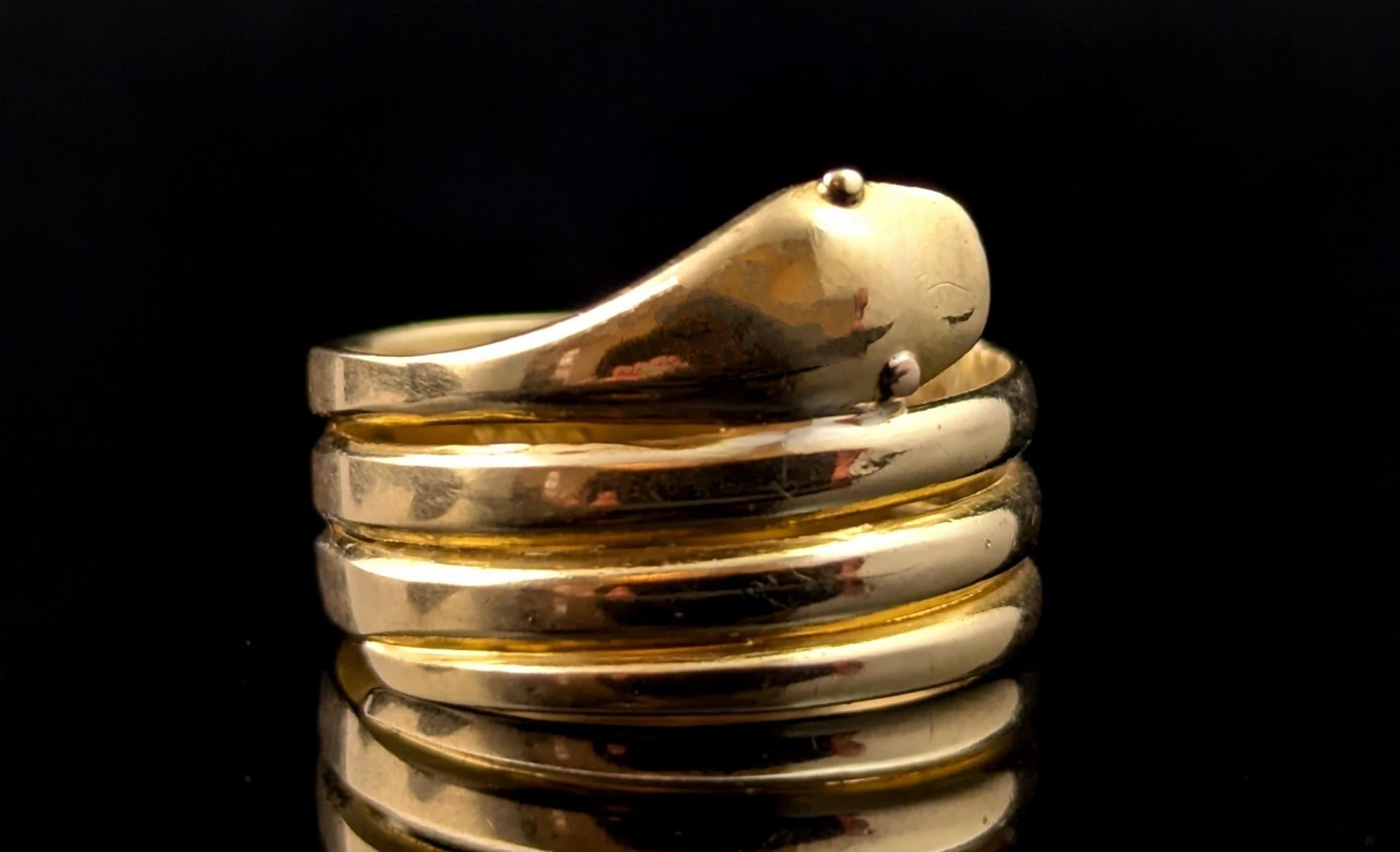 This charming antique, Victorian coiled snake ring is a real charmer.

Coils of rich, buttery yellow gold form the body of this handsome happy snake, the head is modelled at the face of the ring with the snakes tail coiling all the way around to