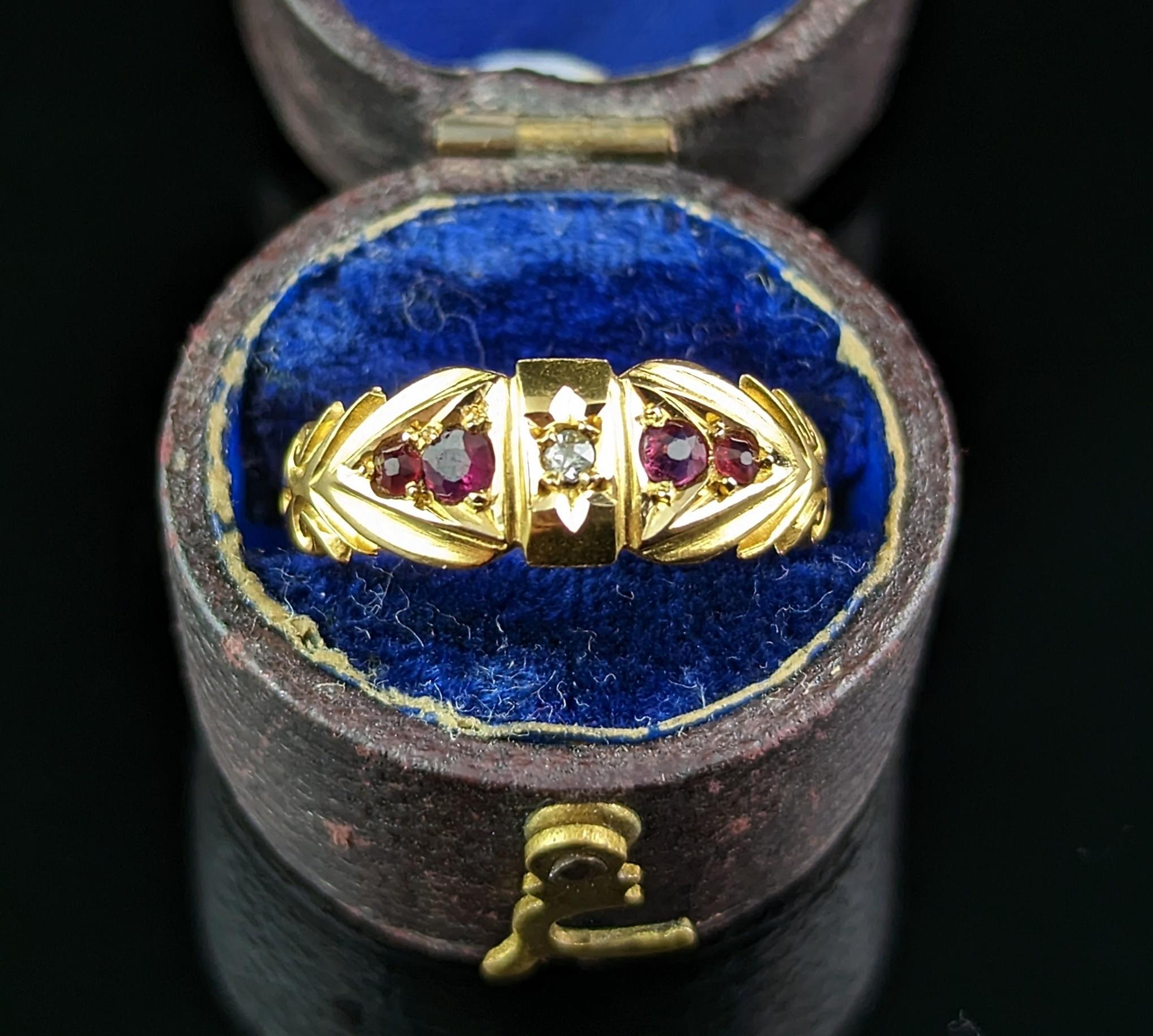 A classic and timeless antique 18kt yellow gold, Ruby and Diamond ring.

It has a very decorative face with deeply engraved shoulders and a front central rectangular shaped panel set with a single diamond chip.

Either side of this central diamond