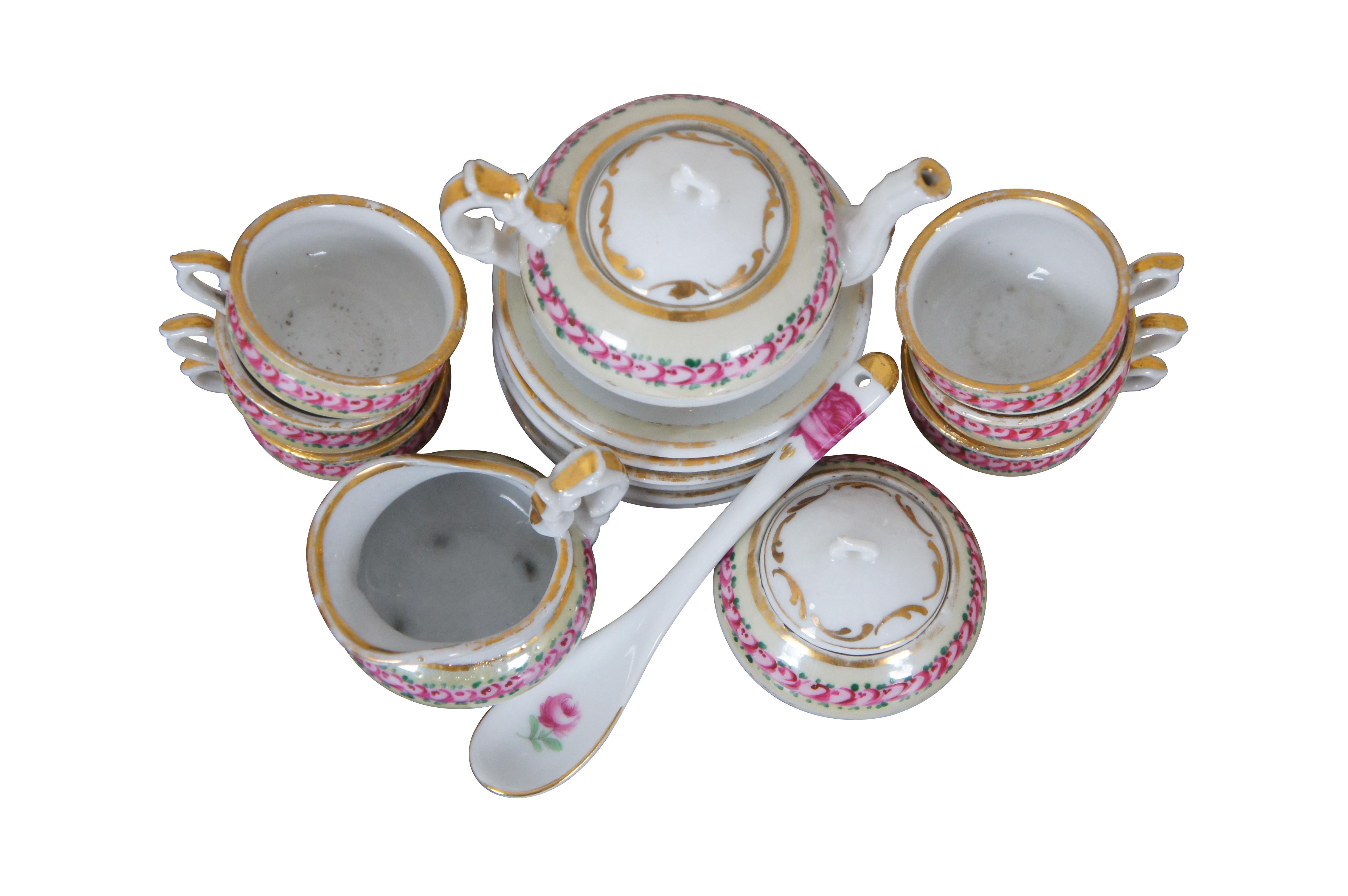 Antique 18 piece child’s miniature / doll sized porcelain tea set, hand painted with pink roses on a cream border with gilded accents. Set includes 6 teacups, 6 saucers, teapot with lid, sugar bowl with lid, creamer, and one coffee spoon. No makers
