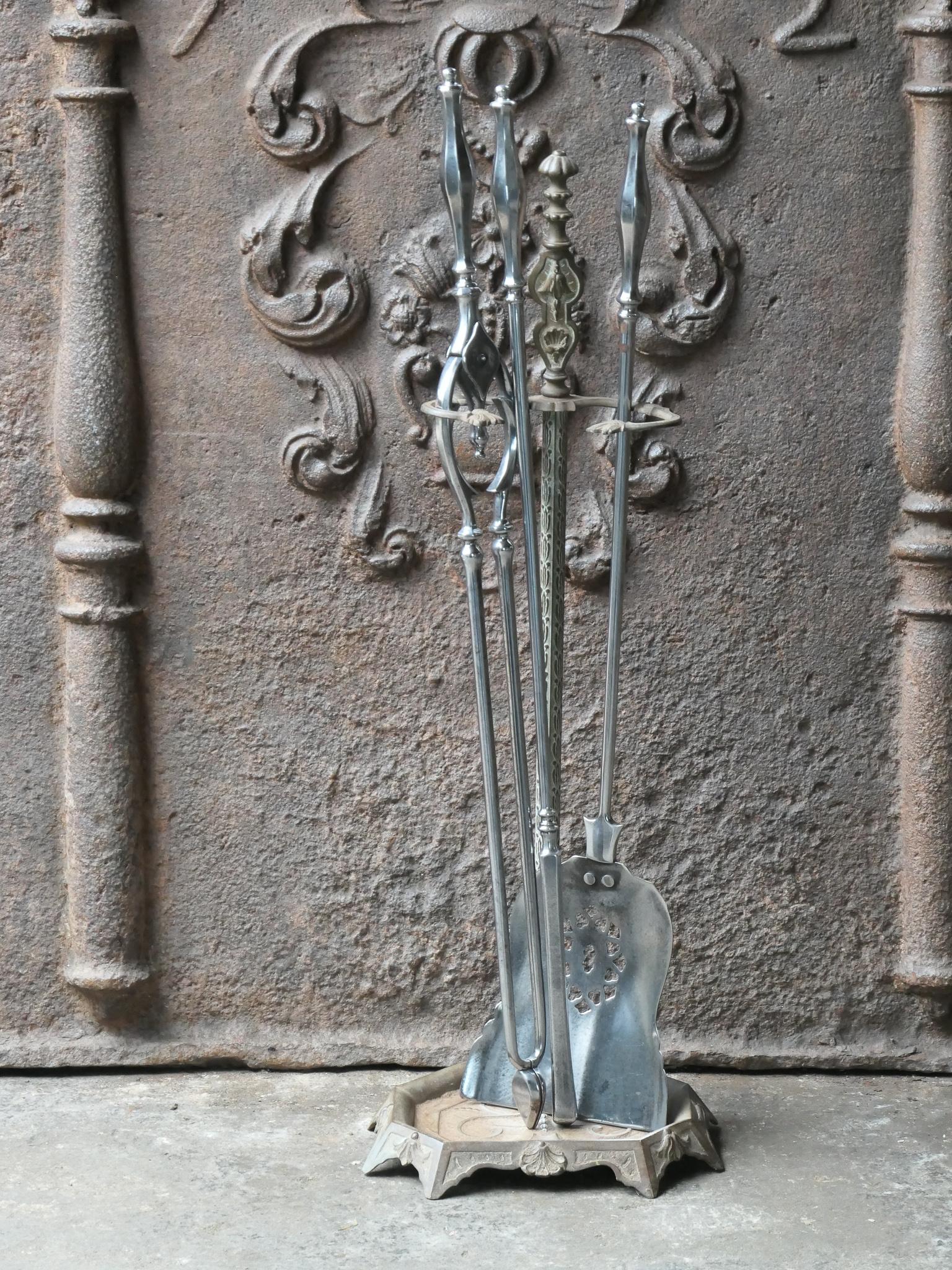 Beautiful 18th - 19th century English Georgian fireplace tool set. The tool set consists of tongs, shovel, poker and stand. The stand is made of wrought iron. The base of the stand is made of cast iron. The tools are made of polished steel. The set