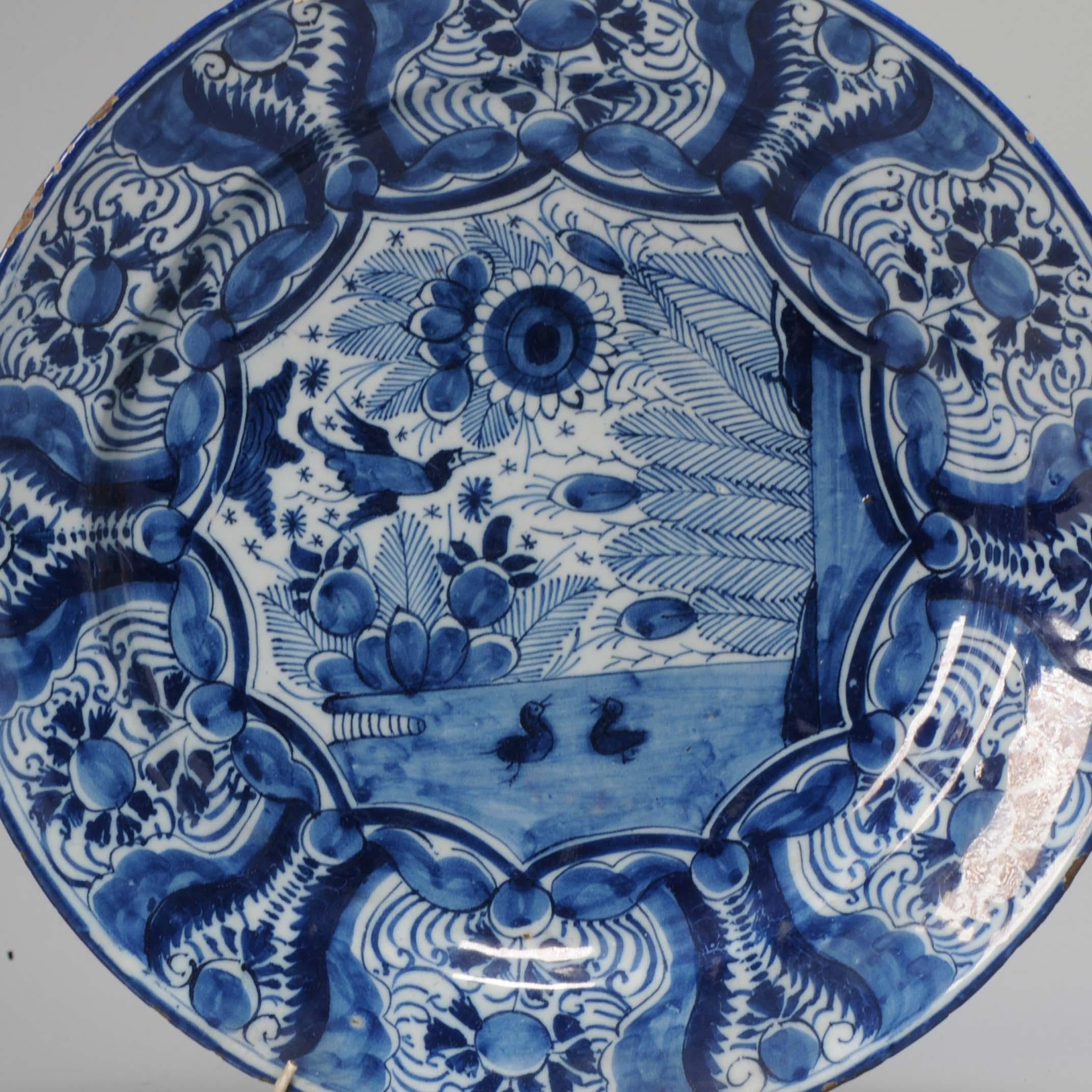 Earthenware dish with a flat rim. Decorated in different shades of blue on a white tin glaze

Condition
typical rimfritting/small chips only. Size 313x55mmm DiameterxHeight
Period
18th century.