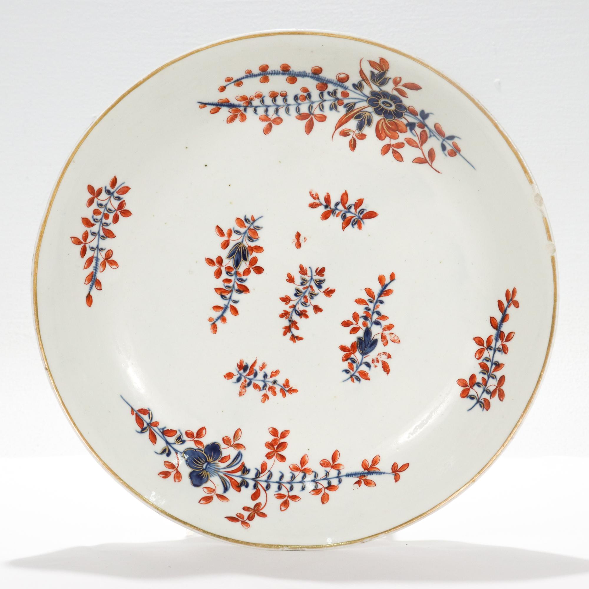 A fine antique Chantilly French porcelain low bowl.

Decorated in an underglaze blue sprig pattern with additional cold painted iron-red leaves and gold highlights and a gilt rim.

The reverse bears old shop labels mistakenly identifying the