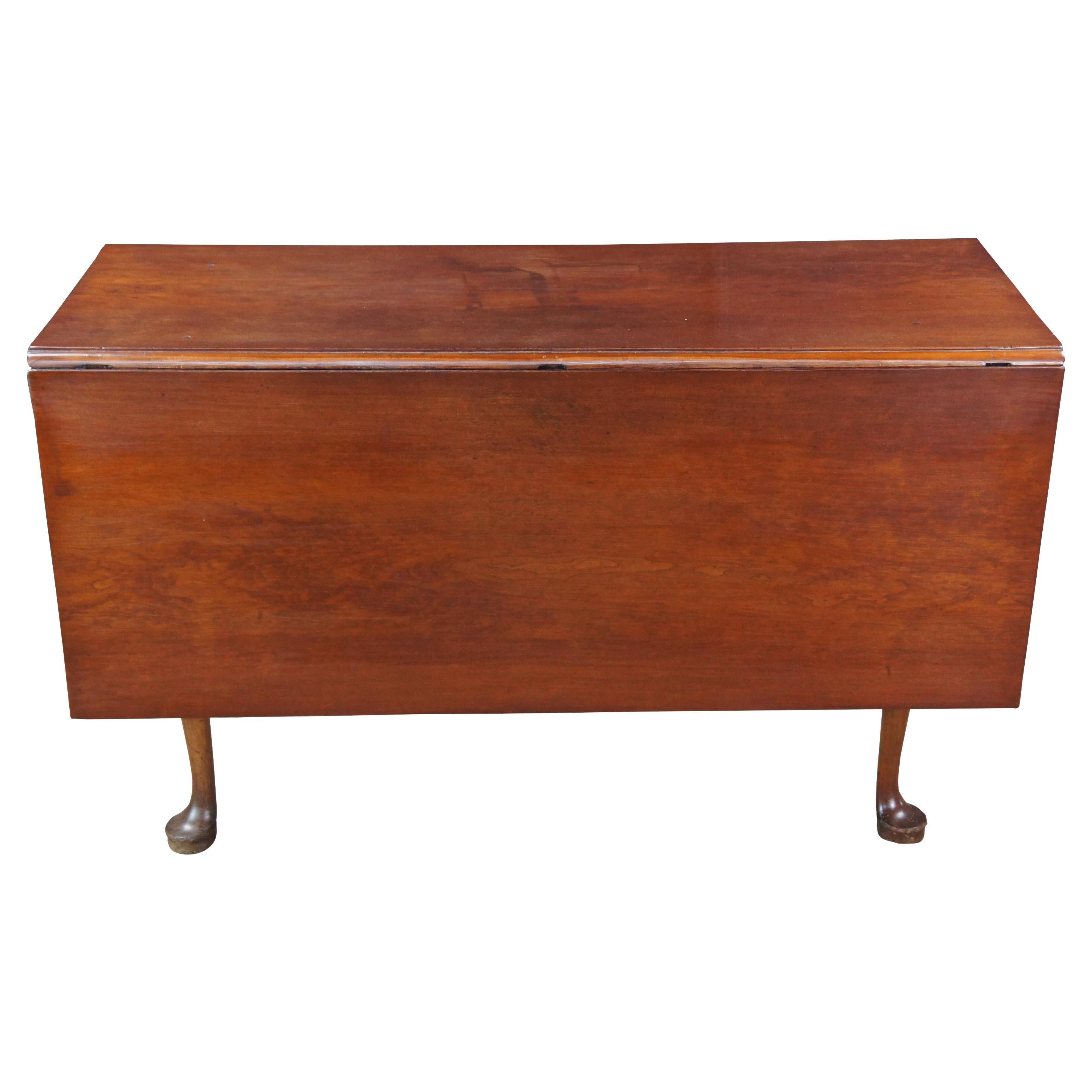 Late 18th Century Geoge III Drop Leaf Table.  Features a rectangular form made from solid cherry with mortise and tenon construction.  Features long slender legs between a serpentine apron and pad feet.  Leaves are supported by gatelegs. 