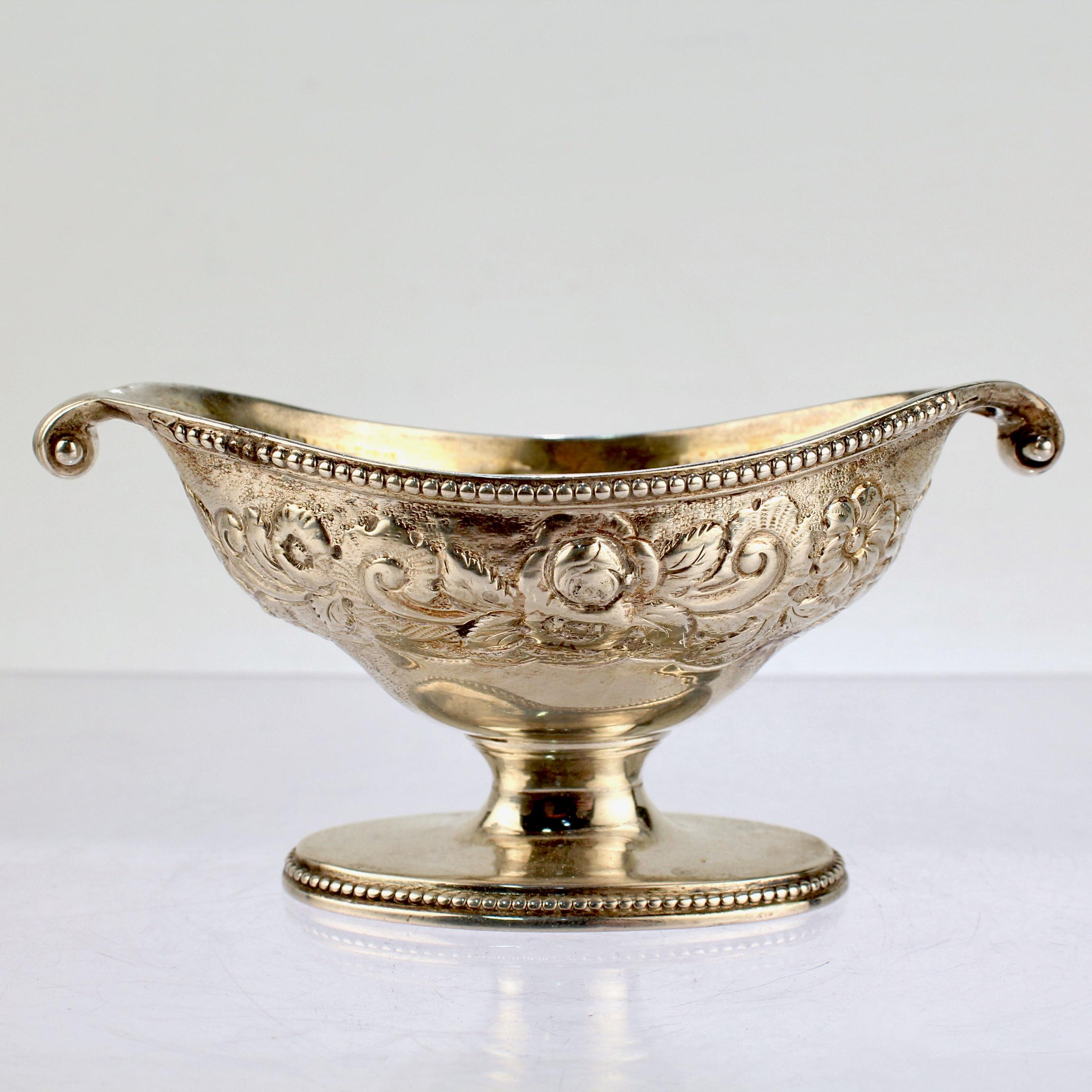 A fine antique Georgian salt cellar.

In sterling silver. 

By Robert Hennell I. 

With scroll handles, a beaded edge & foot, repousse decoration around the body, and a central cartouche with an engraved monogram.

Simply a wonderful period salt