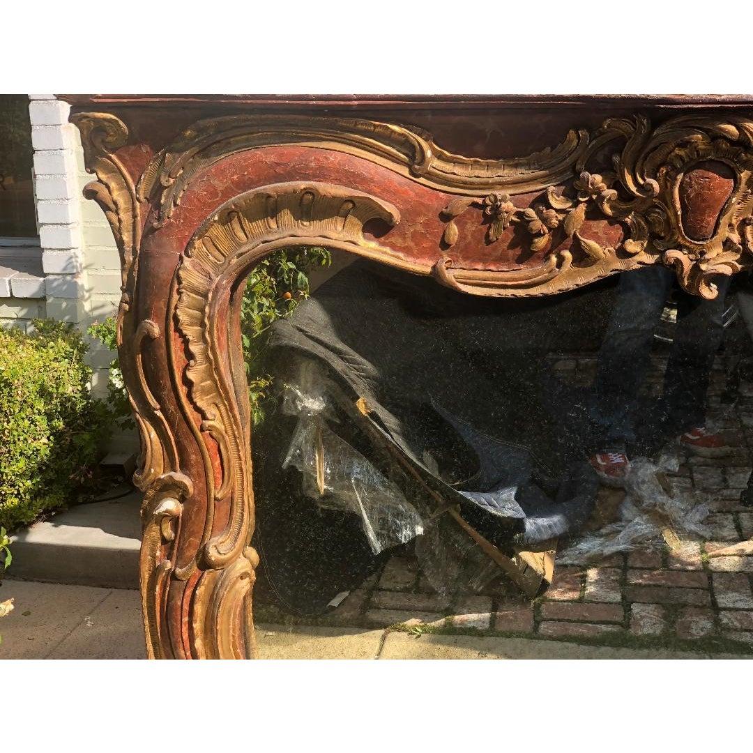 Antique 18th century Venetian style red giltwood over mantel mirror. Once a fireplace surround, converted to a mirror.