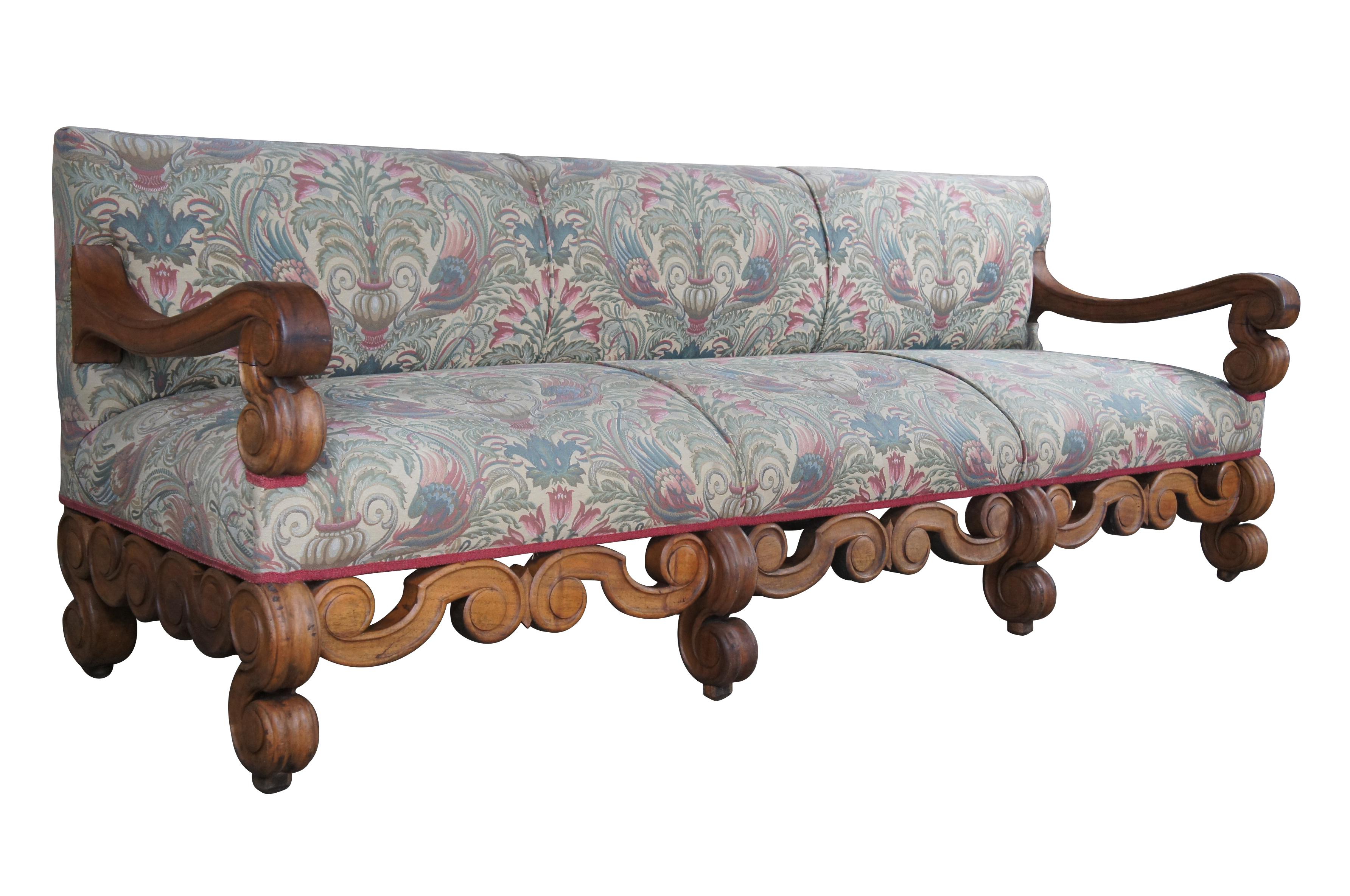 An Impressive William & Mary mahogany Settle or sofa, circa 18th Century.  Featuring heavy scrolled frame with downswept open arms, six legs and Neoclassical floral upholstery.  The beautifully 